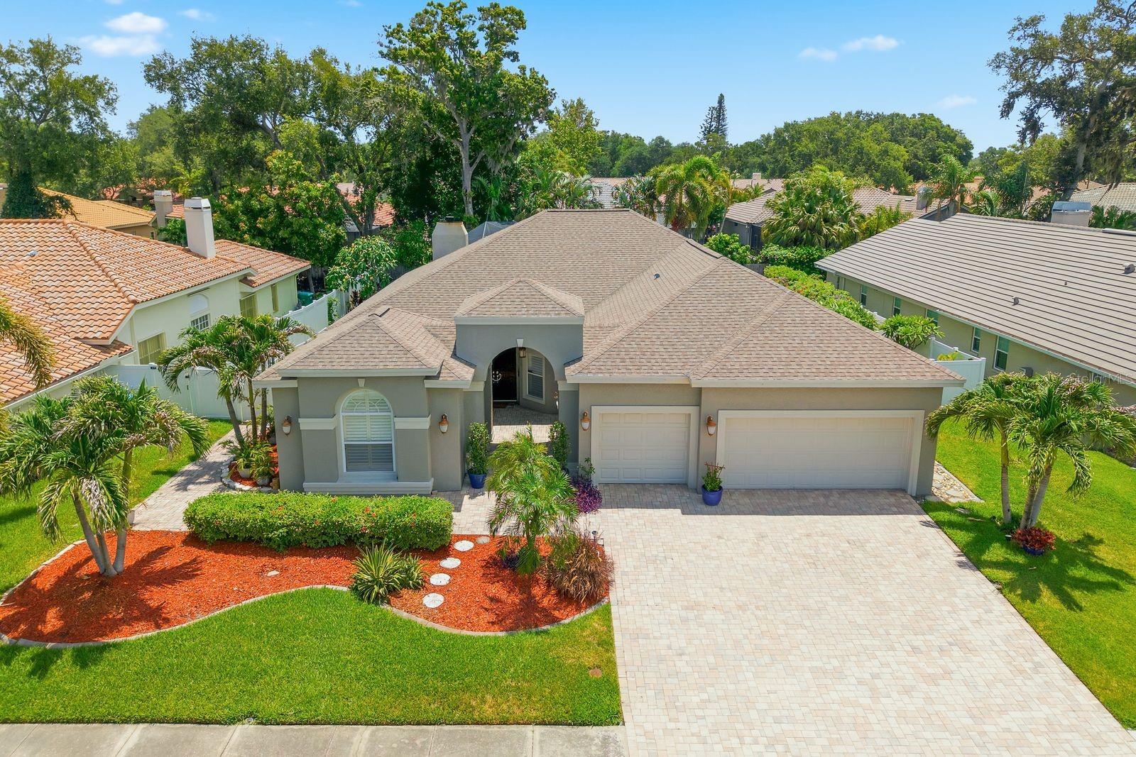 Finding a home in Oak Trail is uncommon. Finding one with a detached Flex Space/Additional Dwelling Unit (ADU), 4 bedrooms, 3.5 bathrooms, a three-car garage, a private pool, and zoned for top-rated schools is truly exceptional. Set on an oversized quarter-acre-plus homesite, this beautifully maintained residence offers the space, flexibility, and lifestyle that today's buyers desire. The thoughtfully designed floor plan provides multiple living and entertaining areas, while the kitchen serves as the heart of the home with granite style countertops, stainless steel appliances, abundant cabinetry, and views of the main gathering spaces. Adding to the home's appeal is the detached Flex Space / Additional Dwelling Unit (ADU), completely separate from the main residence. Whether utilized as a private home office, guest retreat, fitness studio, hobby room, media room, creative workspace, or multi-generational living area, this versatile space provides endless opportunities to fit your needs. Outside, a cathedral-screened pool enclosure, expansive paver patio, and large fenced backyard create the perfect setting for enjoying Florida's year-round outdoor lifestyle. Recent improvements include a 2020 HVAC system and a 2022 water heater, while the three-car garage offers exceptional storage and convenience. Ideally situated just minutes from Palm Harbor University High School and just minutes from everything Palm Harbor has to offer, this is a rare opportunity to own one of Oak Trail's most complete properties.