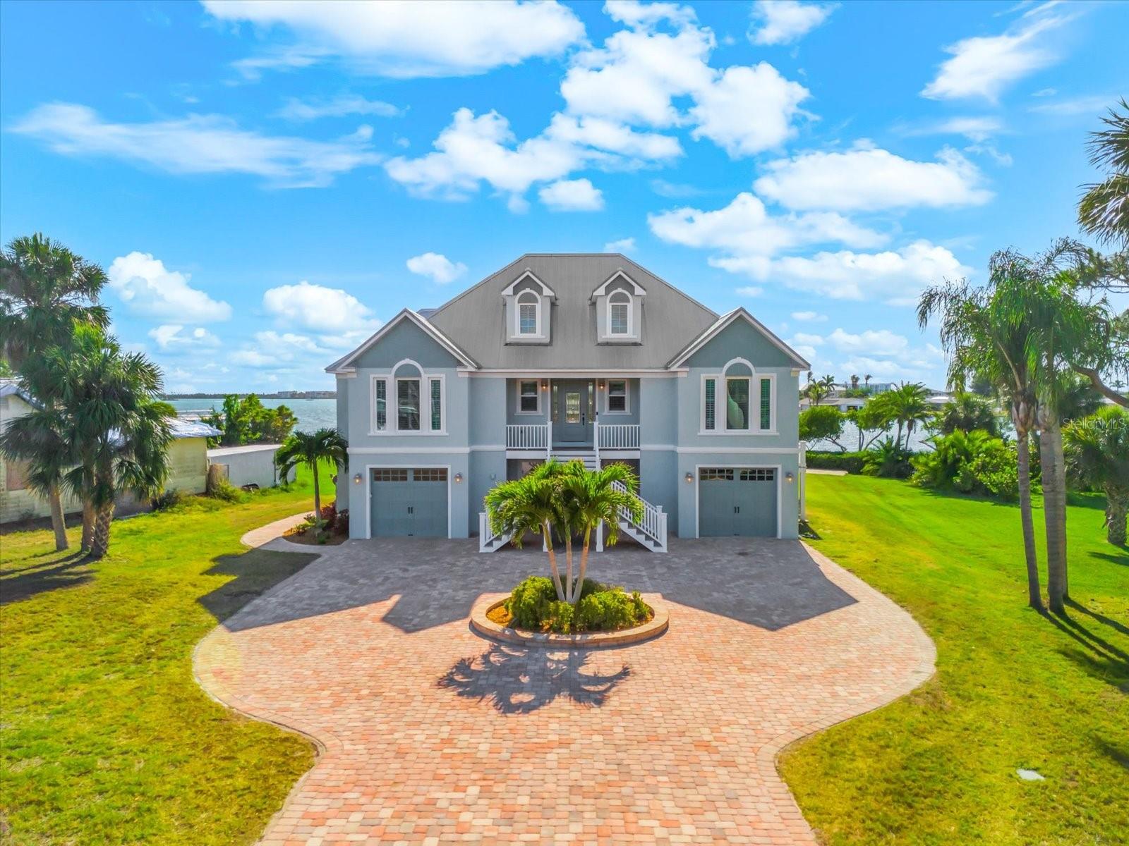 A luxury waterfront escape, built in 2016 with solid construction and set on over a half-acre, this five-bedroom, five-bath home is offered turnkey furnished—arrive and start living. Designed to sleep up to 15, it’s made for effortless hosting and unforgettable stays.

Calm water just steps away, with direct, no-bridge Gulf access. A covered 10,000 lb boat lift with electric and fresh water, plus a fish cleaning station, keeps every day on the water simple. The oversized heated pool and spa anchor a wide paver patio built for both relaxed afternoons and sunset evenings by the fire.

Inside, clean lines and thoughtful finishes define the space—tile floors, custom window treatments, and a beautifully appointed kitchen with granite countertops, soft-close cabinetry, stainless appliances, double oven, pot filler, and a large pantry. Multiple ensuite bedrooms and individual thermostats throughout offer comfort and privacy for every guest.

Upstairs, a loft with Murphy bed and full bath creates a flexible retreat, while the screened, covered Trex porch captures elevated water views and unforgettable sunsets. The lower level, non-conforming space adds bonus living with direct pool access, a game room, storage, and an additional bedroom and bath not included in the official count—ideal for overflow guests. Split garages for three cars and an elevator add everyday convenience.

Built to last with a metal roof and PGT impact windows, this home lets you focus on what matters—boating, entertaining, and soaking in the waterfront lifestyle.