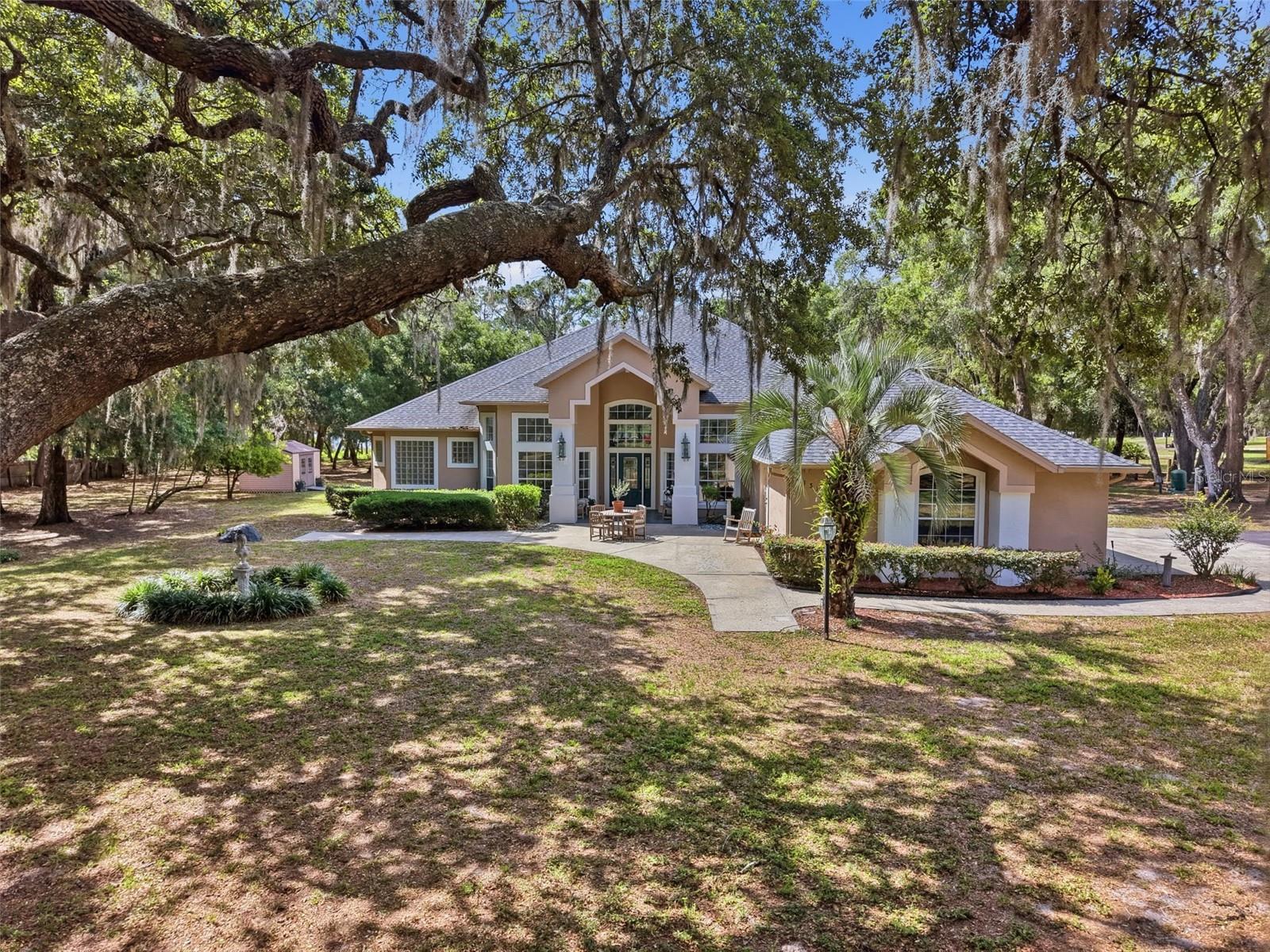 Prepare to be impressed by this custom-built lakefront retreat set on 5 oak-studded acres with peaceful views across private Lake Clifton. With 3,364 square feet of heated living space, this home offers 4 bedrooms, 3 full baths, a dedicated office, and a generous bonus room that could easily become additional bedrooms. The bonus room was even pre-plumbed for a future full bath, making it ideal for creating a true guest suite.

Inside, the layout is bright and open with a desirable split-bedroom plan and dramatic ceiling heights ranging from 9’10” to 23’ in the foyer. Tile flooring runs throughout the main level, while wood plank flooring adds warmth upstairs. The kitchen overlooks the great room, where a gas fireplace anchors the space—perfect for gathering, entertaining, and everyday living.

Relaxation is built in: one bathroom includes a cedar-lined sauna for four, accessible from the bath or the back porch. Enjoy Florida living year-round with a 14x21 screened porch, plus an upstairs balcony with sliding doors and gorgeous lake views.

The primary suite is designed for comfort and practicality with spacious walk-in closets, including one constructed as a safe room with concrete block walls, reinforced ceiling, and a steel door. Outside, you will appreciate the true 3-car side-entry garage with three separate doors, abundant parking, and a paved driveway leading all the way to the street.

Major updates bring peace of mind, including a newer architectural shingle roof, two replaced water heaters, and a new septic drain field within the last three years. Additional features include an emergency generator transfer switch, whole-house vacuum, 4-inch well with water treatment, and hurricane shutters stored in a 10x12 detached shed.

Follow the path to the water and you will find a 60-foot dock with a 16x10 deck at the end—ready for sunrise coffee, fishing, or an afternoon on the lake. Lake Clifton is approximately 77 acres, and skiing is allowed, giving you the rare combination of privacy and true lake lifestyle.

Located in highly desirable DeLeon Springs, this property is just minutes to De Leon Springs State Park, Lake Woodruff National Wildlife Refuge, Downtown DeLand, shopping, dining, and medical facilities. You are also close to the scenic Spring-to-Spring Trail corridor.