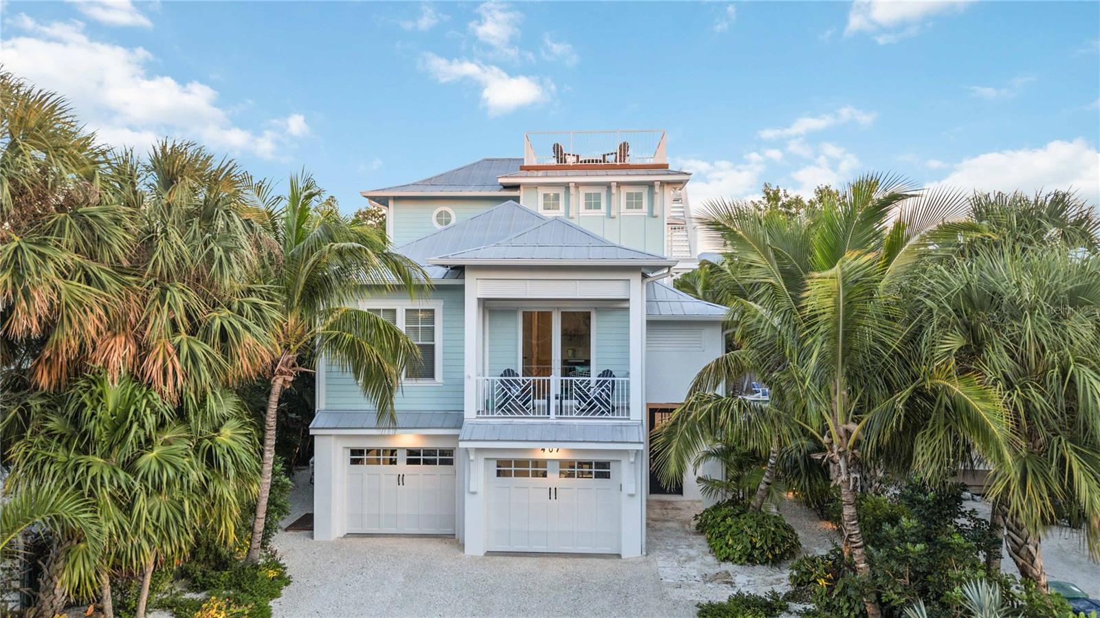 ROR Zoning & Short Term Rentals Allowed!  Experience the epitome of luxury coastal living at 407 Pine Avenue on beautiful Anna Maria Island! Smart Home devices allow for EASY HOME MANAGEMENT and monitoring while you are away. Custom designed and professionally decorated, this 4-bedroom, 4.5 bathroom private residence is nestled right in the heart of Anna Maria offering a special blend of upscale amenities nearby including acclaimed local restaurants, boutique shopping and a kayak launch for adventure seekers! As you approach the home, you are greeted by a custom-cut Key West Coral entry path leading to an inviting foyer equipped with an elevator for your convenience. Hardwood flooring flows elegantly throughout this home highlighted by luxe finishes in every room. Step into the grand open living area properly designed for relaxation and enjoyment. The light filled coastal kitchen is perfect for entertaining featuring an oversized island adorned with quartz countertops, a gas range and energy efficient built-in stainless-steel appliances. The expansive primary suite features a vaulted ceiling, a spacious sitting area, a luxurious bathroom, walk-in closets and a private outdoor covered deck to enjoy gentle gulf to bay breezes. Each ensuite guest bedroom has its own bathroom. Notably, one bedroom serves as a private guest pool house suite, accompanied by a bonus room adjacent to the pool area providing an exclusive retreat for guests. A dedicated den/office space with sliders and a covered deck delivers an ideal vantage point to appreciate the sights and events along Pine Avenue. For a panoramic view of Anna Maria Island, ascend to the rooftop deck to capture 360-degree views of inspiring sunrises & gorgeous sunsets! An outdoor sanctuary has been designed for ultimate relaxation, featuring both covered and uncovered seating areas, a gas fireplace and a large pool with spa enriched by stone pavers and all-weather Trex decking. As evening sets in, professional landscape lighting accentuates this tropical oasis creating an exceptional opportunity to unwind and immerse yourself in the peaceful tranquility found only on Anna Maria Island! Pristine and Model Perfect in every way! This amazing property has been carefully managed and meticulously cared for by its owners who take great pride in the maintenance of this home, and it shows! The property conveys completely TURN-KEY furnished PLUS the sellers are INCLUDING a nearly new SIX PASSENGER GOLF CART, an electric powered beach wagon, house tools and beach gear. All that you need to bring is YOU!