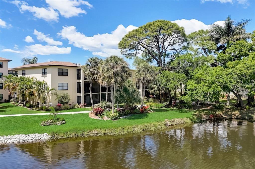 The moment you enter this fabulous move-in ready condo you will want to call it home.  This is the driftwood floor plan which is the largest of the units.  Split floor plan with guest bedroom and upgraded bathroom on one side and the master ensuite has a large walk-in closet and upgraded bathroom with walk-in shower.  The master bedroom view is overlooking the lake and the courtyard.  The walls have been freshly painted and the floors are upgraded bamboo wood floors thru out.  You have a large living room/dining room which flows into the spacious open kitchen with breakfast bar overlooking the family room.  The kitchen has granite countertops and upgraded stainless steel appliances and updated electrical fixtures.  The family room and enclosed glass lanai overlook the tranquil tropical oasis of lush foliage, lake views, gazebo, park benches and bbq grills.  Conveniences: there is an additional secure storage space, mailboxes, trash, and recycle bin available for your use near the elevators.  Low maintenance fees include:  cable, internet, water, sewer, trash, building insurance, recreational facilities, gate maintenance, exterior ground maintenance/repairs, irrigation, pest control, and on-site management.  
The community has a carefree and active lifestyle with lots of amentities and activities.  The clubhouse has a kitchen, banquet room, fitness center, library, billiards, pickleball, tennis courts, heated pool and shuffleboard. Activities such as pot lucks, coffee hour, poker, parties, grilling, just to name a few.  This is a gated community 24/7 with lots of places to walk and bike ride while enjoying the views of the beautiful grounds. Imagine relaxing around the fire pit or curling up with a good book at the gazebo or grilling your favorite meal - ALL just outside in your backyard.  Great location near restaurants, shopping, and only 9 miles to the beautiful beaches of Anna Maria Island.