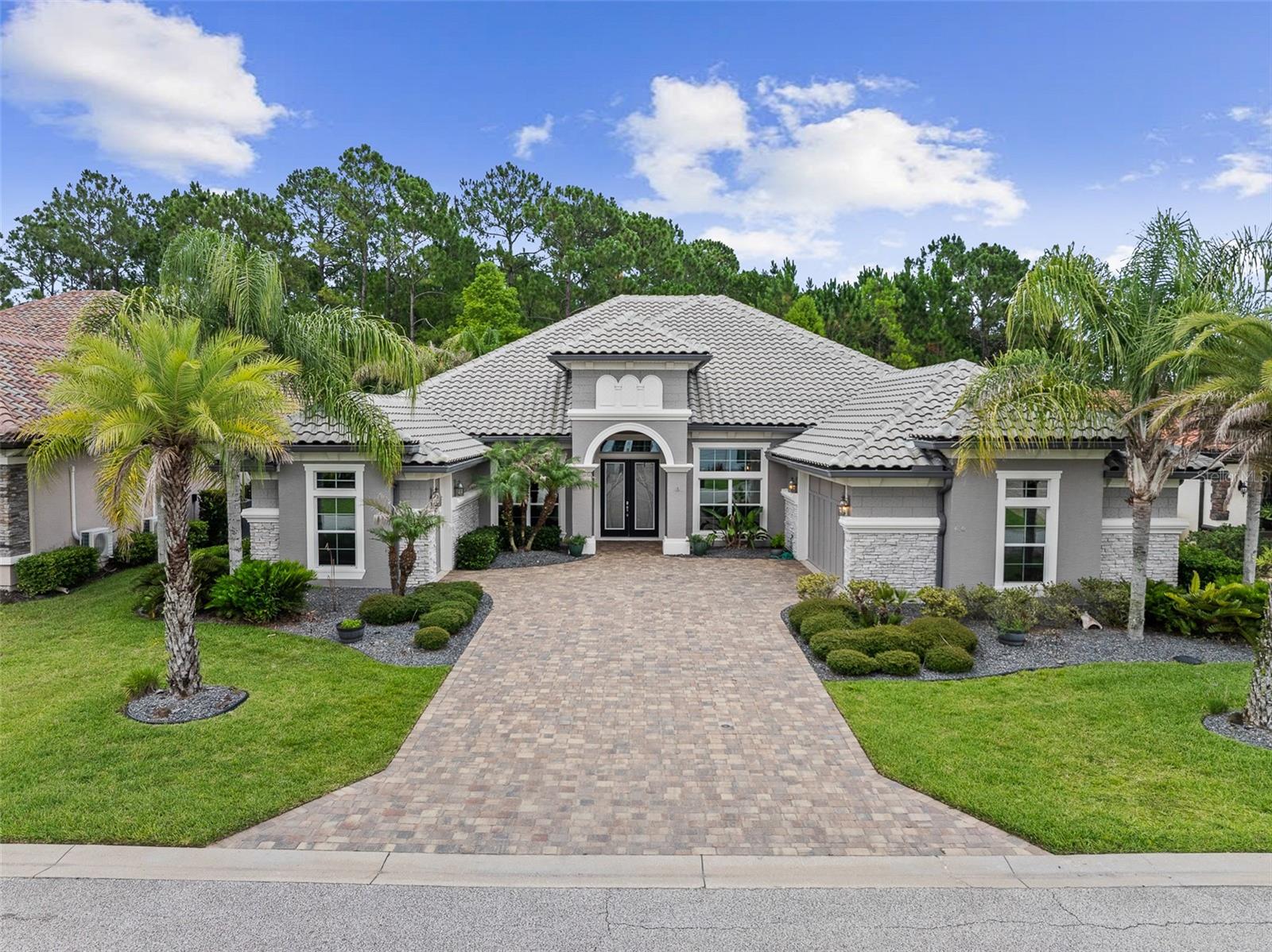 Presenting an exceptional estate residence where timeless elegance meets modern efficiency in one of Plantation Bays most desirable settings. Distinguished by its stately tile roof, craftmanship, and thoughtfully designed floor plan, this remarkable home offers refined living both indoors and out. The residence features 3 spacious bedrooms, 3 full baths, and a private den, complemented by exquisite architectural details including coffered ceilings, crown molding, and rich wood flooring throughout the main living areas. A formal dining room provides an elegant space for entertaining, while the expansive gourmet kitchen is designed to impress with dual center islands, abundant workspace, and a charming separate breakfast room. Outdoor living is elevated to a resort-style experience. The beautifully landscaped grounds showcase a sparkling pool, separate hot tub, outdoor kitchen, and inviting fireplace (with a separate propane tank) creating the perfect setting for intimate evenings or grand gatherings. Additional fencing offers a dedicated space for pets while maintaining the beauty and functionality of the property.
Designed for comfort, convenience, and peace of mind, the home is equipped with a whole-house generator supported by a 250-gallon buried propane tank, as well as solar panels that help offset energy costs. Home also has a Water Filtration System. The oversized 2-car garage is complemented by a separate golf cart garage, providing ample storage for vehicles, recreational equipment, and more. Combining smart design, exceptional amenities, and energy-conscious features, this estate property offers a rare opportunity to enjoy luxury living at its finest in the heart of Ormond Beach!
Buyers of this property will enjoy a substantial discount on the club initiation fees, when they join within 30 days of closing