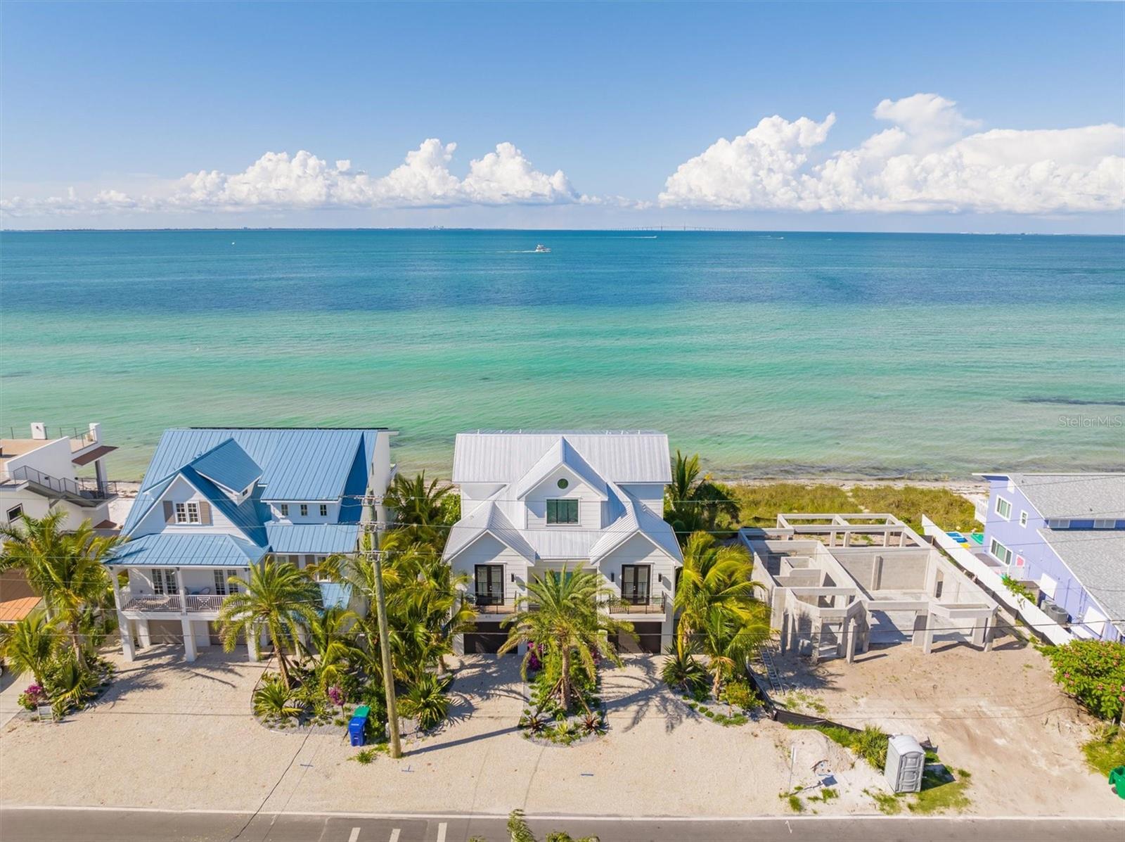 Completed in mid-2022 and built on an oversized 60’ wide lot, this Bayfront house in the North End of Anna Maria offers breathtaking, panoramic, open-water views .  And unlike the Gulf, the sandy beach in front of this home is private!   Only a few short blocks to the shops and restaurants on Pine Avenue, this professionally decorated island home features a large open-plan living area, 4 bedrooms each with an ensuite bathroom, half-bath, a separate living/sitting room on the top floor and extensive balconies overlooking the bay.    This waterfront retreat is built to the highest standards and offers impeccable finishes throughout, including elevator to all floors, extensive trim-work throughout, solar panels, gourmet kitchen, and deep footer pilings.    The gourmet kitchen showcases custom cabinetry, quartz counter tops, gas range, and high end appliances (Wolf, Subzero, Bosch).   Built to minimize on-going costs thanks to roof-top solar panels, two efficient Daikin AC units, multi-panel impact-resistant windows and sliders, Florida-friendly irrigated landscaping, tankless water heater, and extensive insulation throughout.   Technology features include multi-level Wifi hotspots, zoned Sonos sound system, Ring doorbell, security camera system and an in-wall iPad control station, thereby allowing you to remotely control your cameras, sounds system, doorbell, garage doors and thermostats using any smart phone/device. On the ground floor, you'll enjoy your very own tropical paradise featuring an indoor bar and game room area which leads outside to your large heated pool/spa, lush landscaping and miniature golf course, all overlooking the beautiful waters of Tampa Bay and your private sandy beach. The master suite has its own private balcony with nothing but water views and includes a huge bathroom with a walk-in shower and stand-alone soak-in tub.  Don’t forget you can launch your kayak or paddle boards and toss a line and fish right in the bay waters, or simply relax by the pool listening to the waves!