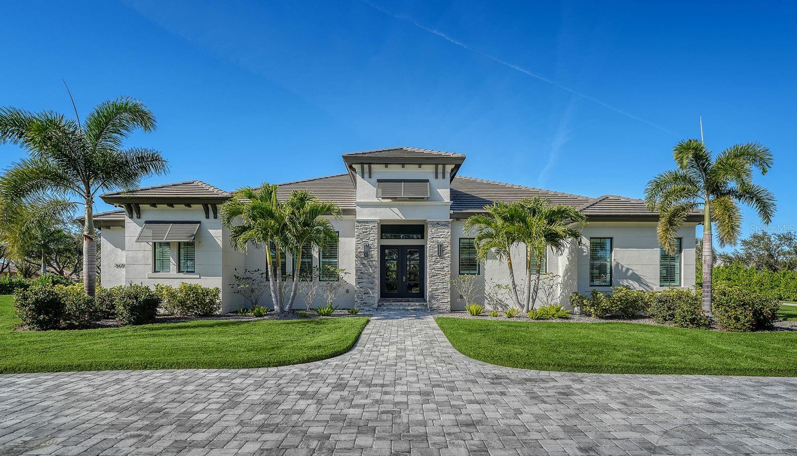 Welcome to the NEWEST dream home in the sought-after, gated community of BENEVA OAKS with only 49 homes! Custom built in 2022 by John Cannon Homes. This award winning "Milina" model is a contemporary West Indies architectural style home with 3,943 of living sq ft (6,152 gross sq ft) with expansive outdoor entertaining spaces and a fabulous pool area. You'll have piece of mind with solid concrete block construction, hurricane windows and doors. This beautiful home features a well-balanced floor plan filled with character, color & lots of light. Sellers added many change orders/additions to this home and it shows! The inviting entry with double doors at the spacious foyer will lead you to a very open concept floor plan with high ceilings and engineered hardwood flooring throughout (except bathrooms). The great room has a cypress beamed vaulted ceiling, an accent wall with floating shelves, an electric fireplace that supplies heat with a remote for changing colors & a built-in dry bar.  The oversized contemporary kitchen and dining room are congenial and warm. The chef's kitchen offers custom wood cabinetry, a large island with a quartzite translucent top with lighting and bar seating. Kitchen appliances include a Dacor luxury refrigerator, Dacor 6 burner gas cooktop and 2 ovens, Bosch dishwasher and a microwave drawer. The dining room/great room have disappearing glass walls that transition to the expansive outdoor entertaining spaces. The primary bedroom suite is sited on one complete side of the home that offers a tray ceiling, his & hers walk-in-closets with custom built-ins and a private door to one of the lanais. The fully private en suite bathroom features marble flooring, a floating dual vanity, soaking tub, a spacious shower and a vaulted ceiling with wood beams. The den/office has a glass corner wall with a barn door and a wood coffered ceiling. Bedrooms #2 & #3 both have private bathrooms and walk-in closets. A 4th bathroom is off the hall from the den/office and enters onto the lanai/pool area for easy access. The family/bonus room is in the back of the home and has powered blinds, a wood accent wall, wood beam ceiling & 10' sliders that open onto one of the lanais. The huge pool deck offers plenty of room and has 2 lanais with wood ceilings that have recently been installed. The PebbleTec pool (23 x 33) has a hot tub (7 x 7) and is heated with both gas and electric and also has a ledge. The outdoor summer kitchen has bar seating.  There are panoramic pool screens, outdoor lights with multiple colors & a mounted TV that make this the perfect home for entertaining. The utility/laundry room has storage cabinets/counters, an extra refrigerator, sink, and a washer and gas dryer. The whole house has CAT 5 wiring and has a control room with equipment in the utility/laundry room. Barn doors are throughout the home, plantation shutters, and 2 tankless water heaters. 4 side load garages have 10 & 12' ceilings.  The garage has epoxy floors, built in cabinets, a slat hanger wall, TV mount, extra lighting, ceiling fan & remote door openers that operate from a remote or cell phone.  The 10' side mount overhead door openers can accommodate a car lift so you could make it a 5 car garage if needed. You'll be surrounded with custom estate-sized homes and this particular home is a RARE FIND in Sarasota because it's a newer build, on nearly an acre (.9377 acre) & minutes to world famous Siesta Key beaches! Hurry on this one!