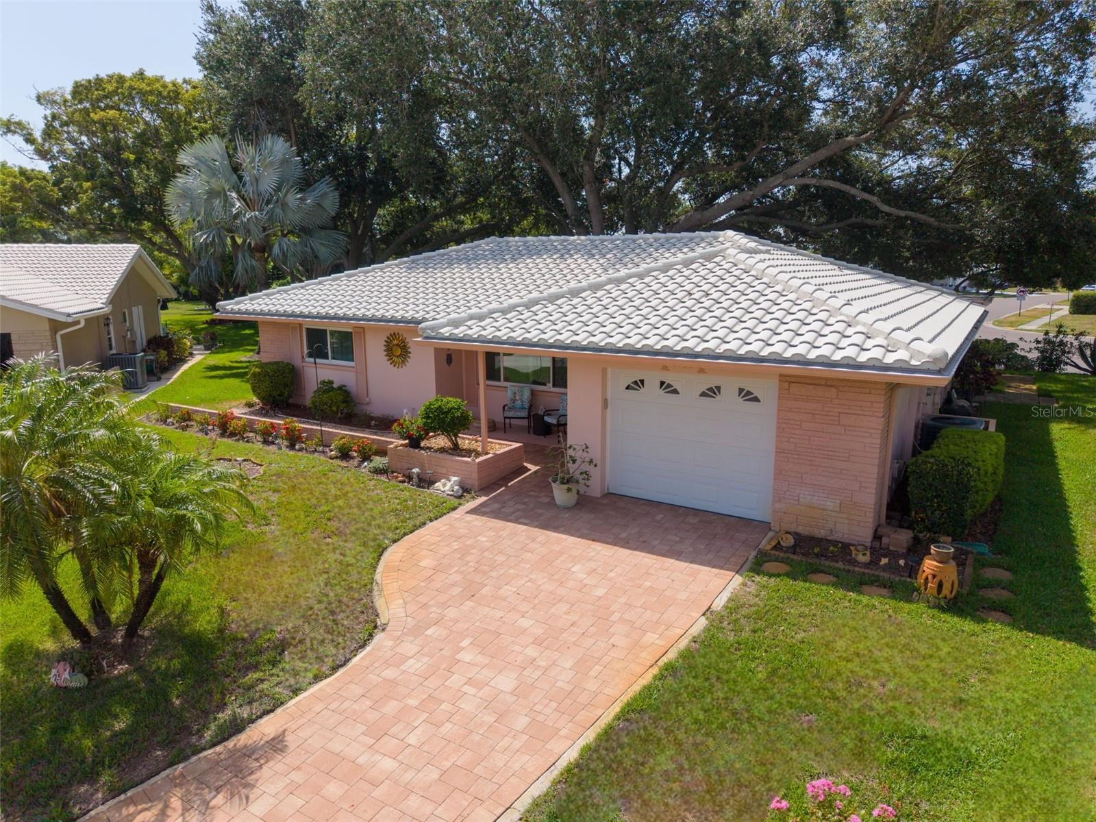Welcome home to this beautifully maintained 2-bedroom, 2-bath home with a bonus screened lanai, nestled on nearly a quarter-acre lot in Palm Harbor's premier 55+ golf community, Highland Lakes! From the moment you arrive, you'll appreciate the inviting curb appeal featuring an updated paver driveway, a durable concrete tile roof, oversized one-car garage with a new (2021) garage door, mature tropical landscaping, and a peaceful cul-de-sac setting. Upon entry you're immediately greeted by an inviting light and bright, open floor plan that is enhanced by wood-like laminate plank flooring, fresh neutral finishes, recessed lighting, and smooth ceilings with no popcorn texture! Designed with both comfort and entertaining in mind, the centrally located kitchen seamlessly connects the living/dining room combo with the spacious family room, creating an ideal gathering space for family and friends. A large glass hurricane-impact sliding door leads to the screened lanai, offering the perfect spot to enjoy your morning coffee, unwind in the evening, or simply take in the lush backyard views. The spacious primary suite provides dual built-in closets and a private en-suite bath with a walk-in shower, while the guest bedroom and second full bath offer comfort and privacy for visitors. Major updates include a (2019) 2.5-ton HVAC, all new hurricane-impact windows throughout, newer hot water heater, and new (2021) garage door! Safely located high and dry in a NON-FLOOD ZONE and NON-EVACUATION ZONE! Life in Highland Lakes is unlike any other, with a low HOA fee granting unlimited FREE GOLF on three private executive courses, tennis, pickleball, bocce, shuffleboard, an active clubhouse filled with clubs, activities, and fitness classes, plus exclusive access to the community's Lake Tarpon lodge with a private boat ramp, fishing pier, and pontoon boats. Residents also enjoy complimentary RV and boat storage and the convenience of golf cart-friendly streets. Just minutes from award-winning Gulf beaches, restaurants, shopping, healthcare, major airports, and the Port of Tampa, this home offers the perfect location, outstanding amenities, and the Floria lifestyle you've been dreaming of!