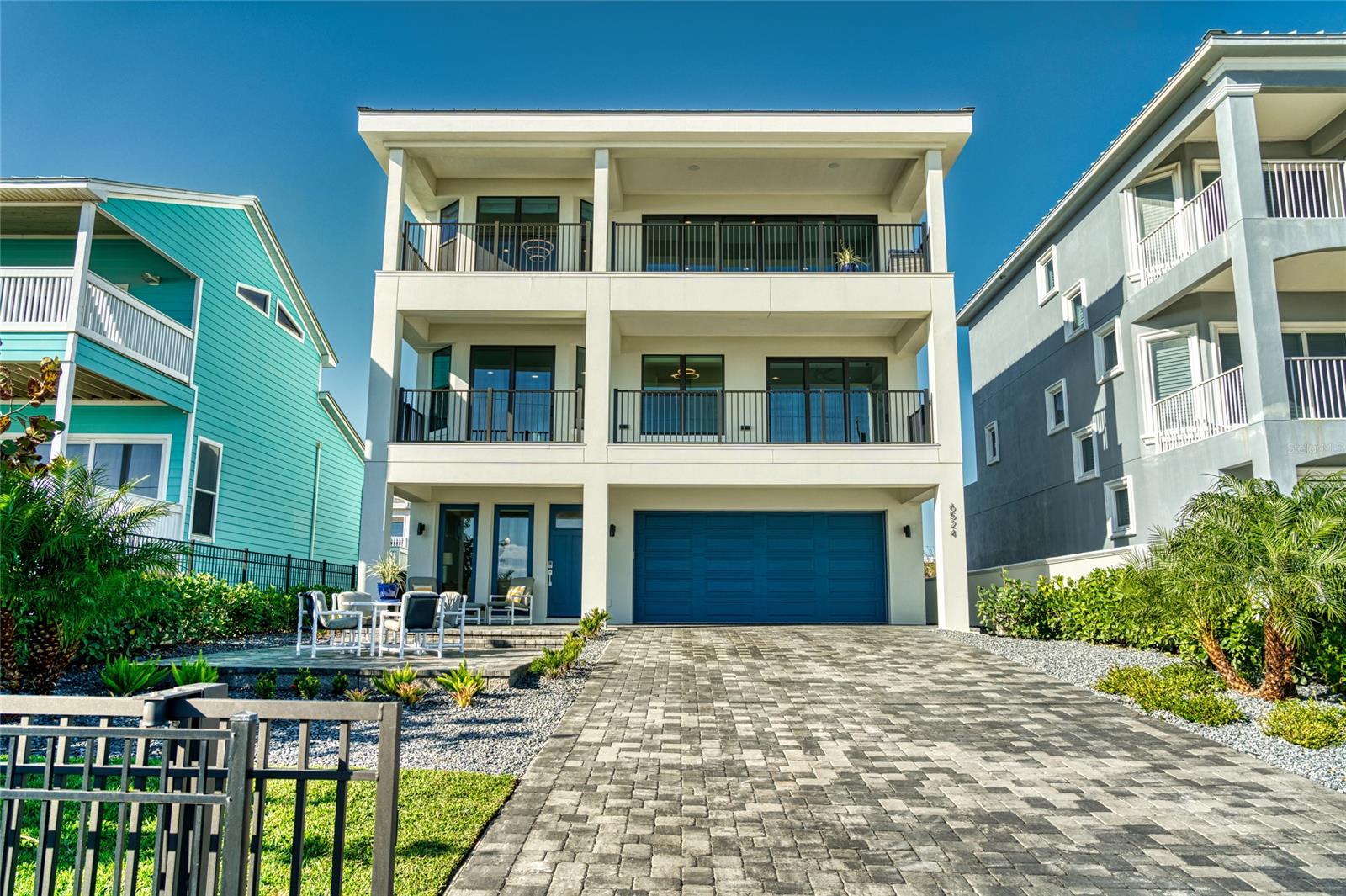 This 2021, 4 bed, 3.5 bath home plus office is waiting just for you. Dip your toes in the warm Florida sand & ocean surf just steps away from your front door. Located in the exclusive New Smyrna Beach Community of Bethune Beach; this portion of the beach is vehicle free. The gated & fenced front yard is perfect for oceanside entertaining with a large pavered seating area & covered lanai. Stepping inside, you’ll find the first-floor family room/media room with wet bar, wood look tile flooring & beamed ceiling. The first floor also hosts a bedroom with en-suite bath, 2-car garage, & access to the grassy backyard area. Take the stylish elevator or the solid wood stairs to the second floor where you’ll find the large primary suite with glass sliders leading to the full-length ocean facing balcony. This suite includes a huge walk-in custom closet, luxury carpet, morning coffee station with refrigerator, & stunning en-suite bathroom with dual vanities, separate toilet room, & a large tiled walk-in shower. Also located on the second floor are two more bedrooms (one also ocean facing), a shared full bath with dual sinks, & a laundry room. The third level comprises the main gathering spaces. Wood look tile flows as you step out of the elevator & find ocean facing wall-to-wall windows & glass sliding doors off the living room & formal dining room. Entertain family & friends around the giant quartz kitchen island with counter seating for up to 8. This kitchen has high-end appliances & tons of storage with pull-out drawers, a huge California Closet designed walk-in pantry, Five Star 6-burner gas-top stove with griddle, oversized stainless steel farmhouse sink, double Samsung wall ovens, & an under-counter ice-maker. Enjoy the ocean breeze & a cup of coffee while watching the Florida sunrise from your own private balcony off of the living room. The office with barn door & an half bath are also on this level. Custom window treatments & sound system have also been installed.