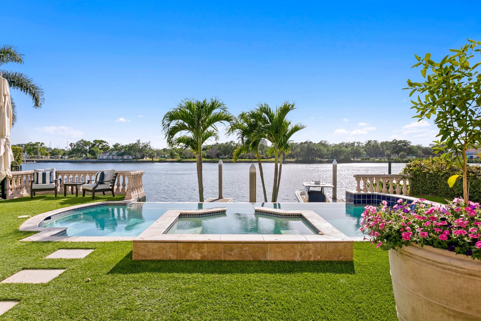 FULLY RENOVATED HARBOUR ISLAND WATERFRONT SINGLE FAMILY HOME WITH YACHT DOCKAGE. Welcome to this masterfully renovated Harbour Island estate representing the finest in luxurious living and refined sophistication. Located in this guard-gated waterfront enclave, Modern Mediterranean architecture and a tranquil courtyard lends an ambiance of warmth to sleek interior spaces boasting soaring ceilings, professionally curated finishes and state-of-the-art design. An extensive $2.0m, down to the studs renovation blends interior high style with rarely found 2 deep water boat slips available for yacht dockage . An elegant courtyard fountain and impressive impact-glass double door entry welcome you to spectacular waterfront living in this Island paradise. The transitional design offers an elegant, suspended stairway that descends to the flowing living spaces, stunning hardwood floors, floor-to-ceiling windows/doors and water views beyond. Grand living on the first level includes numerous areas for entertaining -- a living room with remote-gas fireplace, formal dining room, family room with coffered ceiling and custom cabinetry, along with a lounge area and premier entertaining bar with dual Sub-Zero wine refrigerators. In the center of it all is a dream kitchen to please the most discerning chef. An expansive custom island and marble countertop/backsplash is only the beginning. Premium Wolf, Sub-Zero and Bosch appliances, professional-grade gas range, and beverage refrigerators are complemented by an inviting dining area that delivers a spectacular water view sunrise to sunset. Retracting glass doors open to a personal oasis with a covered lanai, waterfront infinity edge pool, spa, and low-maintenance turf lawn with terraced seating. A spacious in-law/au-pair casita provides a first level living room and kitchenette with private courtyard entry, a second level bedroom with en-suite bath, and sitting room with balcony accessed by a secondary spiral staircase. The second level primary suite is tucked into a private wing of the home and delivers pure decadence with a sitting area and wood-burning fireplace, beverage station wet bar and retracting doors to a sweeping waterfront terrace. Opulence is found in a large waterfront custom closet, 2 additional closets, and the marble-clad primary bath offering a custom MTI deep soaking tub and Kohler steam shower. The remaining private spaces of the home are found on the second level and include 3 gracious guest bedrooms, 2 full baths and a laundry room. Additional appointments include upgraded systems (electrical, plumbing, HVAC), impact doors/windows, custom hardwood and marble flooring, custom cabinetry, smart home controls that include Lutron lighting and motorized shade systems, custom Restoration Hardware fixtures, California Closets throughout, exterior gas lanterns, 2-car garage with 4 car capacity with included hydraulic lifts, tankless water heater system with whole-house water filtration, and a brand new (2025) concrete tiled roof. Harbour Island is a private, guard-gated community set in the heart of Tampa, offering around-the-clock security and a prime urban location. Just outside the neighborhood, residents have walkable access to some of the city’s most popular attractions including the Riverwalk, Water Street, Amalie Arena. The island itself features green spaces, playground, and marina facilities. Available fully furnished at additional cost.