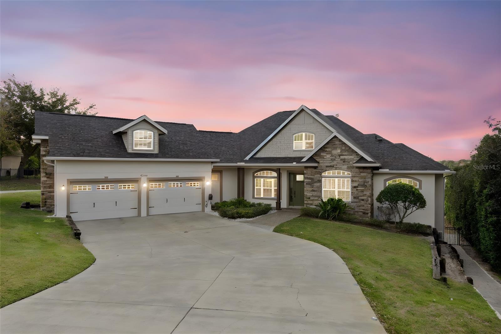 One or more photo(s) has been virtually staged. Experience the best of lakefront living in this exceptional custom-built home, located within the gated community of Lake Fischer Estates. Thoughtfully designed to capture expansive south-facing lake views, this residence is filled with natural light and offers a seamless balance of comfort, style, and functionality.

The main living level features an open-concept layout ideal for both entertaining and everyday living. A separate dining area flows into the updated gourmet chef’s kitchen, complete with a Thor 8-burner gas range and double oven, Kucht hood, Viking refrigerator, wine fridge, double copper farmhouse sink, quartz countertops, and generous prep space for gatherings of any size.

Indoor and outdoor living blend effortlessly with access to a wraparound balcony spanning the entire rear of the home. The living area, kitchen, and primary suite all open to this shared space, featuring a daybed swing and unobstructed lake views—perfect for morning coffee, relaxing evenings, or hosting guests.

The spacious primary suite serves as a private retreat with bay windows, dual vanities, dual closets, and a walk-through shower with soaking tub. The lower level offers two additional lake-view bedrooms and a flexible bonus room, all opening to a covered lanai with direct pool access. A finished hidden room behind a bookcase provides a unique space ideal for entertaining, movie nights, or casual gatherings, complete with a dry bar and lounge-style seating.

The third level includes two additional private bedrooms, each with an ensuite bath and walk-in closet, offering comfort and privacy for family or guests.

Outdoor amenities enhance year-round enjoyment and include a lakeside pool, fire pit with built-in seating, mini putting green, and an outdoor kitchen—creating an inviting setting for both relaxation and entertaining. Conveniently located with easy access to the East-West Expressway, Florida Turnpike, downtown Orlando, Restaurant Row, and area attractions. Schedule your private tour today and discover everything this remarkable about this home .