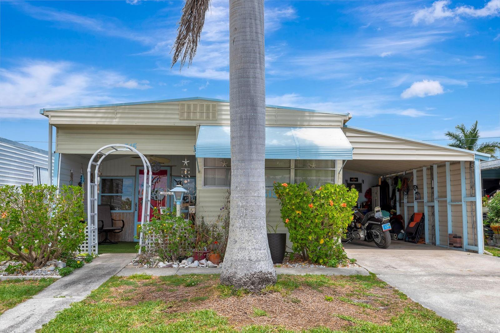 You don't want to miss out on this LAND OWNED/LOW HOA 135 unique furnished 640 square foot home offering two bedrooms and one bathroom. This home has been cared for from head to toe and is clean as a whistle.  Recently added brand new a/c keeping it nice and cool.  Upon entering, you are greeted by a welcoming entryway with an inviting atmosphere.  The covered porch addition offers protection from the elements.  Walking in the front door is a time capsule.  Forget the boring plain walls and plain decor, this place is filled with heart and soul and lots of thoughtful eclectic memorabilia and a cozy sitting area.   Right behind this room is the second bedroom featuring natural light. Walking into the main living room your greeted with another living area, laminate floors and abundant light.  The open kitchen has bright cabinets going with the Florida fun vibe this place exudes from head to toe.  The bathroom has been updated as well.  The primary bedroom provides ample space for rest and relaxation, with the charming decor and coastal-inspired touches adding to the cozy atmosphere. The bright color scheme and vibrant walls further enhance the welcoming feel of the home.  You can walk out to your private spacious outdoor space featuring privacy and continued fun Florida inspired decor.  This is your own little oasis with green turf to make it all the more fun and easy to care for.  This place is a great opportunity if your seeking something different and well thought out with inspired fun energy inside and outdoors of this home.