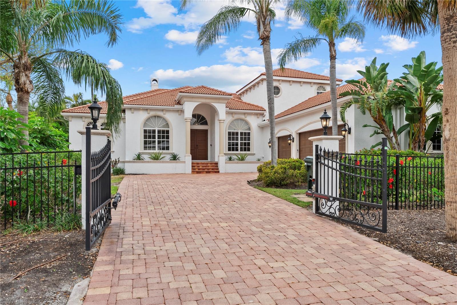 Price Reduced!  Spacious island living, strong weekly rental income, and a prime north Siesta Key location come together in this beautifully maintained 5-bedroom, 3-bath furnished home just steps from beach access No. 1 at Shell Road on Big Pass. Built above base flood elevation of 11 feet, this property offers a valuable advantage on Siesta Key, along with the comfort, privacy, and usability today’s buyers are looking for. Fully gated and walled, the home sits on a generous lot surrounded by lush tropical landscaping, with an oversized 3-car garage and large paver driveway providing ample space for vehicles, beach gear, and a golf cart.
Inside, the home offers large, open living spaces ideal for gathering and entertaining, featuring 12-foot ceilings, crown molding, arched openings, travertine flooring, and a spacious living room with gas fireplace. The kitchen includes stainless steel appliances, oak cabinetry, a breakfast nook overlooking the backyard oasis, and easy flow to the separate dining area and main living spaces. French doors open to a large terrace overlooking the tropical backyard, while an additional side terrace offers a private place to relax.
The main-floor primary suite is a standout, offering direct terrace access, an oversized bedroom, two walk-in closets, and a luxurious en-suite bath with dual vanities, soaking tub, walk-in shower, and floor-to-ceiling travertine. Two additional bedrooms and a full bath are also located on the first floor, creating a functional and flexible layout. Upstairs, two generous guest bedrooms, a full bath, and a wet bar with beverage fridge provide an ideal retreat for visitors, with one bedroom opening to a private terrace overlooking the backyard.
Designed for indoor-outdoor island living, the backyard is a true tropical oasis with mature landscaping, a heated saltwater pool with fountain, paver deck, large turf area, outdoor shower, and an exceptional tiki hut bar and outdoor kitchen complete with a built-in gas grill, two bar fridges, and porcelain countertops. An additional fenced side yard offers extra space for pets or outdoor enjoyment.
Offered turn-key furnished, with a five-bedroom layout, generous lot size, multiple terraces, abundant storage, central vacuum, and expected 2026 rental income of $190,000. This home is an outstanding opportunity for those seeking a private Siesta Key retreat, income-producing investment, or both. Ideally located near world-renowned Siesta Key Beach and just a short drive to downtown Sarasota’s restaurants, shopping, and cultural attractions, this property offers the best of island living with convenience, comfort, and flexibility.