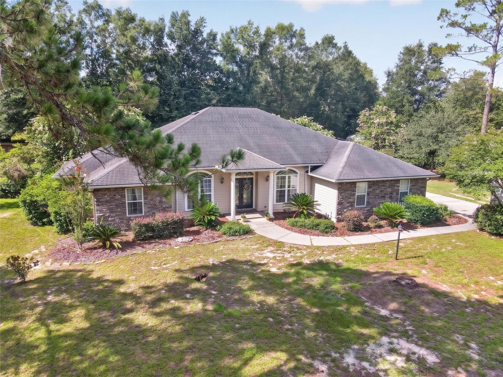 Well-built home on a peaceful one-acre lot with NO HOA minutes from the charming towns of High Springs and Newberry.  Enter the front door and you are greeted with arched windows and crown molding throughout. Floor plan includes a library/office, formal dining room, and a living room with fireplace. Gourmet kitchen features custom wood cabinetry, granite countertops, and stainless-steel appliances.  Primary suite offers a double tray ceiling with lighting, private porch access, dual granite vanities, separate shower, jacuzzi tub, and two walk-in closets. The spare bedrooms are oversized, and the second bathroom also includes a double-vanity layout.  The outdoor features include a screened patio wired for a future hot tub, Shed, garden, and fully fenced backyard. Additional highlights: newer water heater, 2019 AC, generator plug, holiday outlets in the eaves, and high-speed fiber optic internet available.  Minutes from the Santa Fe River, Springs, Hiking/Biking Trails, and High Springs Shopping and Restaurants.  Zoned for excellent schools.  Don't miss the chance to make this one-acre retreat yours.
