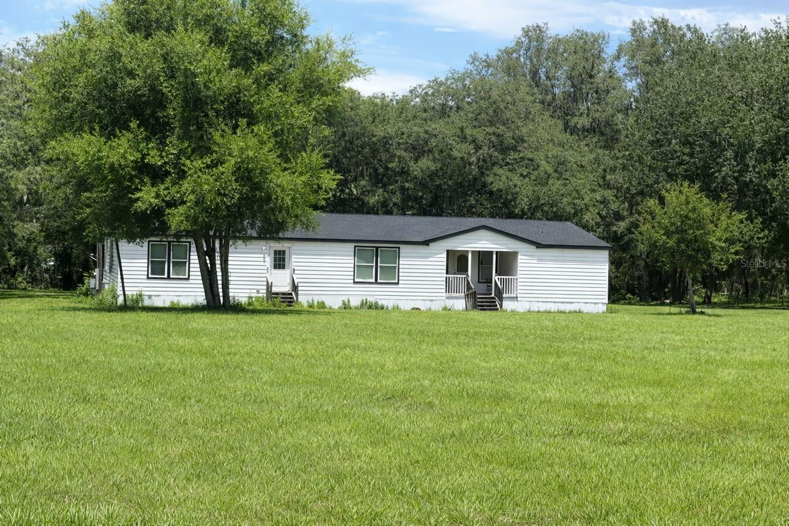Experience peaceful country living on 2.74 acres in one of the most beautiful areas of Pasco County. Located just off Curley Rd only 5 miles north of Hwy 54 this spacious 4 bedroom, 3.5 bath   2,912 sq. ft. of newly remodeled living space with an exceptional blend of comfort, functionality, and land rich freedom.
This 40x76 2007 home features cabinetry and storage galore, walk in closets, and a desirable double split bedroom layout. The primary suite includes a generous 13x12 retreat and a private ensuite bath. The large kitchen offers beautiful cabinetry, an island with electricity, and seamless flow into the family room, dining area, and great room with fireplace perfect for everyday living and entertaining.
Step outside to enjoy an open yard with huge mature trees, a 12x24 aluminum work shed. The property also includes a beautiful pool, ideal for cooling off and enjoying Florida summers, pool service is included, providing effortless maintenance and year round enjoyment.