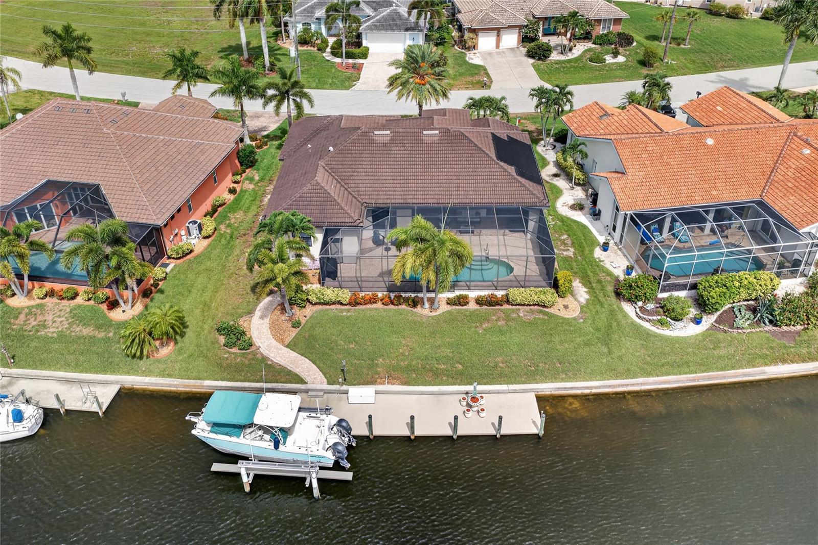 Multiple offers, highest and best offers due by 12pm Monday 7/20/26. WATERFRONT LIVING MEETS CUSTOM LUXURY. Perfectly positioned on a breathtaking WIDE BASIN CANAL with SAILBOAT access to Charlotte Harbor and the Gulf, this custom-built DM Dean residence offers an extraordinary blend of timeless craftsmanship, elegant design, and the Florida boating lifestyle—all just approximately 20 minutes to open water.

Designed to maximize both the stunning waterfront views and effortless indoor-outdoor living, this 3-bedroom + den, 2-bathroom, 3-car garage home welcomes you with soaring ceilings, refined architectural details, and an open floor plan that feels both grand and inviting. The spacious living room showcases coffered ceilings and dramatic 90-degree pocketing sliders, seamlessly disappearing to create an uninterrupted transition to the expansive lanai. Additional pocket sliders from the dining area flood the home with natural light while framing spectacular water views from nearly every angle.

At the heart of the home, the chef's kitchen is designed to impress with granite countertops, rich wood cabinetry, stainless steel appliances, a large center island perfect for gathering, and a generously sized pantry providing exceptional storage.

The private owner's suite is a true retreat, featuring elegant tray ceilings, direct slider access to the pool, an impressive 13' x 10' walk-in closet, and a luxurious ensuite bath complete with dual granite vanities and a spacious Roman shower. The guest bedrooms are thoughtfully designed, including one with a walk-in closet and another perfectly positioned to enjoy peaceful water views. A versatile den with French doors is ideal for a home office, library, or additional guest space. The guest bath also serves as a convenient pool bath with direct lanai access.

Outdoor living is nothing short of spectacular. The expansive covered lanai offers abundant space for entertaining, dining, or simply relaxing while overlooking the sparkling pool and tranquil wide basin canal views. An outdoor shower enhances the resort-style experience, while a solar heater and new 2025 pool pump adds peace of mind.

For boating enthusiasts, this property is truly exceptional. The impressive 10' x 47' dock is equipped with a 10,000-pound boat lift, providing quick, bridge-free sailboat access to Charlotte Harbor and the Gulf of Mexico in approximately 20 minutes—making spontaneous sunset cruises, world-class fishing, and waterfront dining part of everyday life.

Located in one of Punta Gorda's most desirable waterfront communities, this exceptional custom home offers the rare combination of luxury finishes, quality construction, and premier boating access. This is more than a home—it's the Southwest Florida lifestyle you've been waiting for.