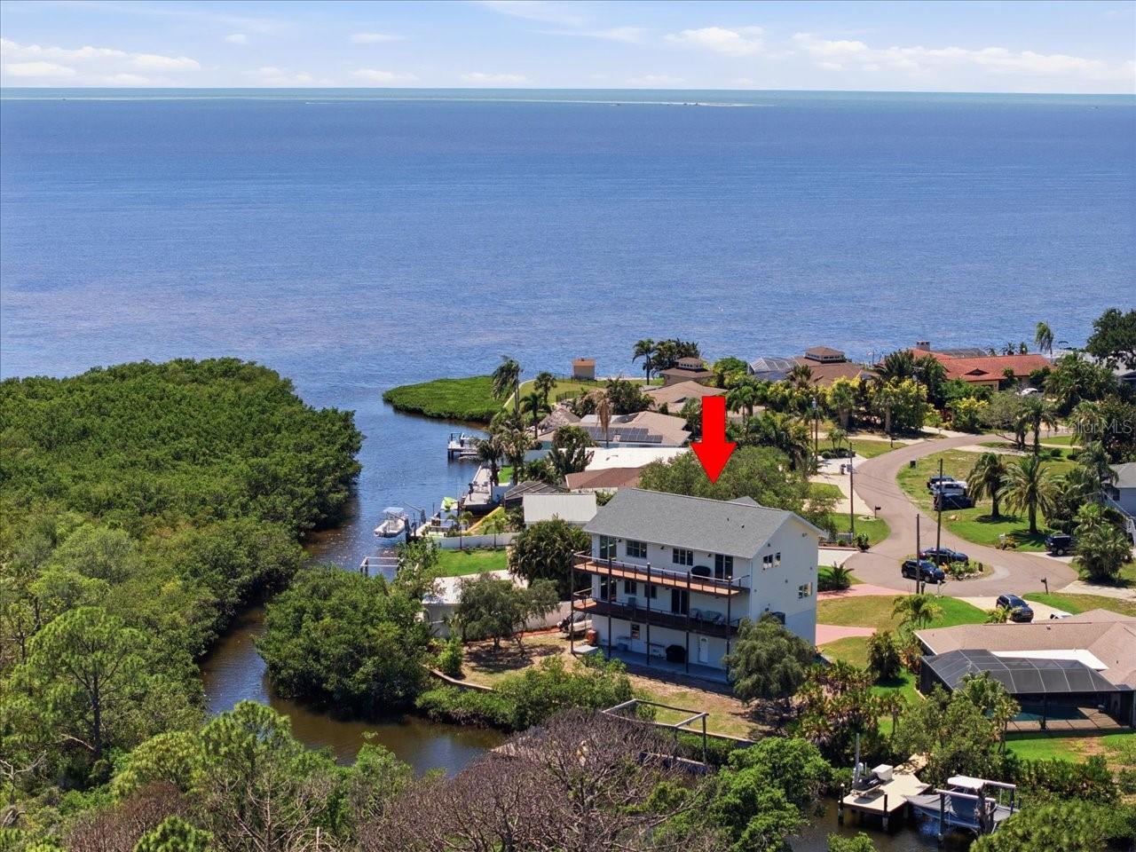 Located at the end of a quiet cul-de-sac on scenic Snead Creek in beautiful Tarpon Springs, this custom-built  3 bedroom with media room and office- which could easily be restructured to be bedrooms if needed- waterfront estate offers panoramic views of the Saint Joseph Sound and the Gulf of Mexico, along with exceptional privacy, space, and craftsmanship.
Designed for both luxury living and functionality, this three-story residence features the main living area on the top floor to maximize breathtaking water views. The expansive great room and sitting area showcase stunning Gulf vistas, built-in media cabinetry, new luxury vinyl flooring, fresh interior paint, and abundant natural light throughout. An office/den and powder room are conveniently located off the main hallway.
The spacious kitchen is designed for entertaining and offers solid oak cabinetry, stainless steel appliances, center island grill, breakfast bar, eat-in space, and adjacent formal dining room. Sliding glass doors open to an expansive deck off the kitchen and living area, creating seamless indoor-outdoor living. Off the kitchen is an oversized laundry room that includes a utility sink and an enormous pantry/storage closet. 
The second level hosts the private bedroom quarters. The primary suite features a beautifully appointed ensuite bath with Jacuzzi soaking tub, slate finishes, and private access to the covered waterfront deck. Both the primary suite and second guest bedroom offer sliding doors leading to the covered balcony to enjoy serene water views and Florida sunsets. Bedrooms two and three are connected by a Jack-and-Jill style bathroom and spacious walk-in closet. Also on level 2, a dedicated media room with surround sound, built-in cabinetry, and projection screen provides the perfect space for movie nights or entertaining guests.
The ground level offers an oversized garage with room for two vehicles plus additional storage for a small boat, trailer, gardening equipment, and recreational toys. The U shaped garage also features extensive closet storage and rear access.
Outside, the covered patio overlooks the peaceful waterfront setting and offers plenty of room to add a pool. The newly installed dock includes electricity and boat pilings. (Dock currently has no motorized lift.) The setting is exceptionally private and tranquil.
Built with durability and efficiency in mind, this home includes:
New roof (2024),
Two new HVAC systems (2024),
Impact windows,
Icynene insulation,
Wiring for a permanent generator,
Breakaway garage walls for storm protection,
31 structural pilings extending 20 feet into the ground,
Water softener system, and a 
Reverse osmosis filtration system.
A rare opportunity to own a thoughtfully engineered waterfront home with incredible Gulf views, privacy, and endless possibilities in one of Pinellas County’s most desirable coastal communities.
