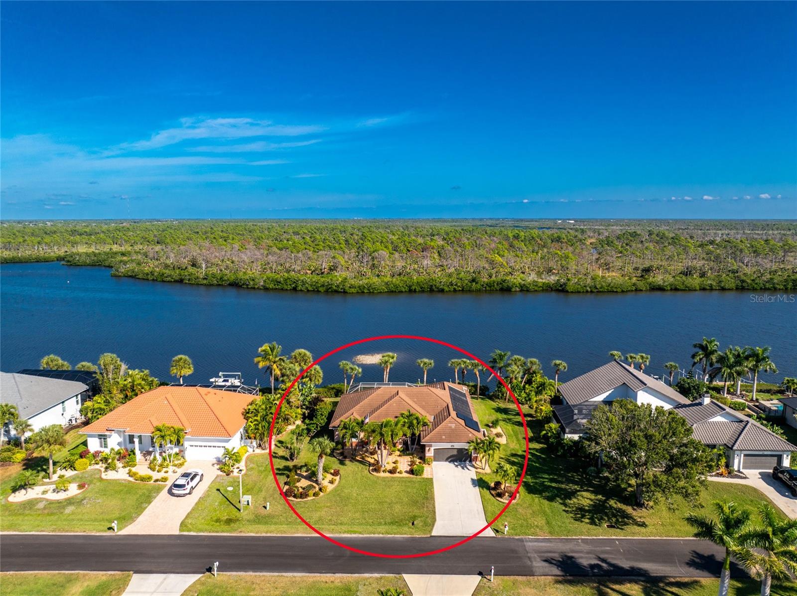 JUST - WOW!  What a spectacular panoramic view of Coral Creek, as soon as you enter! Coral Creek is one of the most pristine and natural bodies of water in this entire area! And it's not just about the view - This stunning spacious home is being sold FURNISHED (with just a couple of exceptions) so no need to spend $1000's more on furniture!  The open floor plan features a formal living and dining room, with sliding glass doors opening onto the lanai. The kitchen is a cook's delight, with plenty of cabinetry, granite countertops, and stunning backsplash. Appliances include: BRAND NEW French door refrigerator, microwave, smooth top stove, and dishwasher (all GE)  There's a pass through to the lanai, making entertaining a breeze! The butler's pantry provides all the storage you might need for your food items or your pots/pans/small appliances! The built in desk area w/tumbled marble backsplash is a great place to set up your laptop and printer, and perhaps a cookbook or two!  Dinette/breakfast nook is  handily located in between the kitchen and family room with sliding glass doors opening on to the lanai. Speaking of the family room, this is where you are sure to gather and watch a football game or movie! There's an electric fireplace for some extra ambiance, tray ceiling and a decorative bar! The primary bedroom features easy care laminate flooring, tray ceiling and ceiling fan, two walk in closets and another set of sliding glass doors to the lanai, providing a GREAT WATER VIEW, The Primary Bath has updated plank tiled flooring, updated vanity w/granite countertop and double basins, new mirrors, and COMPLETELY UPDATED ROMAN SHOWER. Guest bedrooms both have ample room so your guests won't feel crowded, plus ceiling fans and wall closets. Guest Bath has a combo tub/shower for those who enjoy a nice soak! Inside laundry houses the Samsung washer and dryer, Two car garage has pull down stairs, with access to the attic, and an automatic garage door opener. The lanai and pool area are the HIGHLIGHT of this home, with pavered decking and wrap around seating area. The beautiful solar HEATED pool has a sparkling pebbletec finish (done in about 2020) and the HUGE POOL CAGE WAS REPLACED IN 2023 - built strong to withstand wind! Tile Roof new in 2020, overhead garage door in 2020, and AC in 2018.  BEST OF ALL, THERE'S A PHOTOVOTAIC SOLAR SYSTEM FOR WHOLE HOUSE, saving you thousands on your electric bill. (Last month the seller's electric bill was less than $30!) IMPACT WINDOWS  provide peace of mind, and the StormSmart screens protect the lanai.  CORAL CREEK is perfect for kayaking, paddle boarding and shallow draft boating access on out to Lemon Bay and pristine beaches. Cape Haze Windward is a deed restricted subdivision, with an 18 hole golf course in its midst. Shopping is close by, and famous Boca Grande, known for it's tarpon fishing, white sandy beaches, and celebrity visitors are just minutes down the road and over the causeway.  There are numerous airports that provide fast and easy access, depending on where you are travelling from: Punta Gorda Airport (PGD), Sarasota International (SRQ), Fort Myers (RSW), and Tampa International Airport (TPA) are all within a reasonable drive. Homes with this natural scenic view don't come on the market very often, So don't delay!