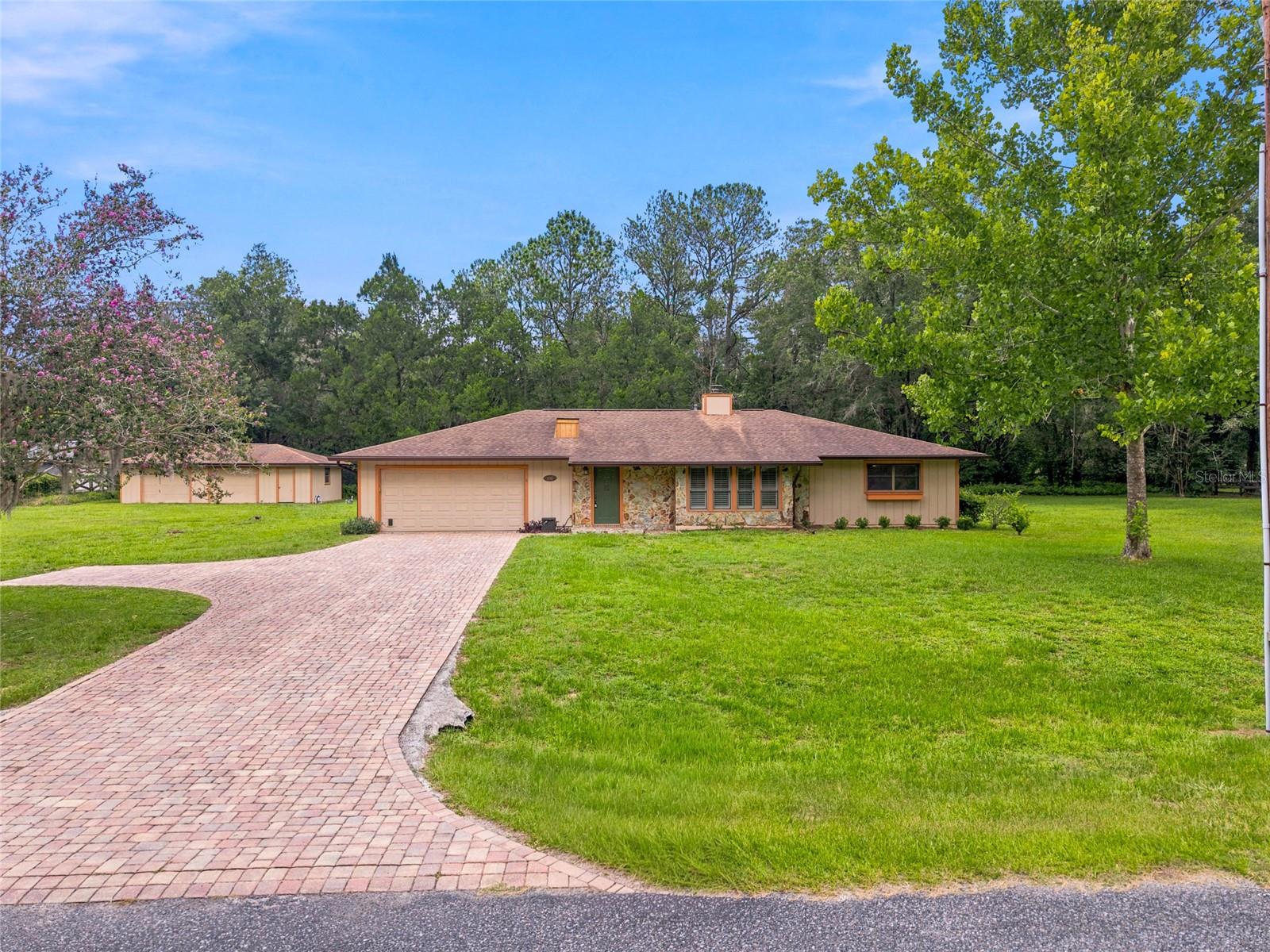 Virtually Staged. Nestled on a private one acre lot in a peaceful Southeast Ocala neighborhood, this charming ranch style home offers space, privacy, and endless possibilities. The property has a unique setting in the middle of town close to top rated schools, shopping, entertainment and hospitals, while still offering a peaceful setting on a quiet street. Just off the foyer is a floor to ceiling glass atrium for year round gardening. The main living areas include a spacious living room with plantation shutters and a brick wood burning fireplace, formal dining room, and a well appointed kitchen featuring granite countertops and a large pantry. Convenient to the kitchen is an oversized laundry room offering additional storage leading to an attached two car garage. The primary suite is light and airy with lots of natural light and plenty of space to relax after a long day. Two additional bedrooms are down the hall with a shared guest bathroom. The back yard is a summer oasis with shade trees, plants, palms, a large patio area, and a refreshing in-ground swimming pool with a brand new pump - all ready for enjoying the Central Florida lifestyle year round. At the back corner of the property is an additional two bay garage for the car enthusiast, or it would also make a great workshop with electric already in place. You do not want to miss out on this rare SE Ocala opportunity. Call today for a private tour!