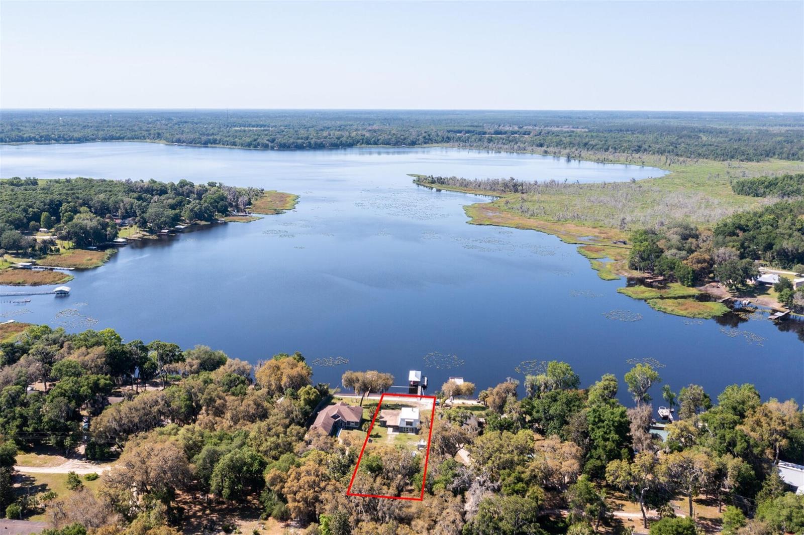 Welcome to your waterfront retreat on beautiful Little Orange Lake! This stunning 4 bedroom, 3 bathroom home offers breathtaking lake views, spectacular sunsets, and an impressive list of recent upgrades, making it truly move-in ready.

Relax and unwind from the extended panoramic enclosed Florida room, where wall-to-wall lake views create the perfect setting for morning coffee or evening sunsets. The open and inviting floor plan features a beautifully updated kitchen with crisp, modern finishes, abundant cabinetry, a dedicated coffee bar, and a formal dining area. The living room is filled with natural light and offers picturesque views of the lake.

The spacious first-floor primary suite, added in 2025, is a private retreat featuring its own dedicated A/C system, new windows and doors, and a luxurious oversized en-suite bath. Wake up each morning to peaceful lake views right from your bedroom. Upstairs, you'll find three additional bedrooms and a full bath, providing plenty of room for guests.

This home has been thoughtfully updated throughout, including a complete remodel in 2021 with a new roof and new appliances. Additional improvements include a new HVAC system, remodeled she shed, and a new dock with boat lift and two Jet Ski lifts in 2022; a new septic system, drain field, and water filtration system in 2024; and the beautiful primary suite addition in 2025.

Outside, the fully fenced property is designed for enjoying the Florida lifestyle year-round. Spend your days boating, fishing for trophy bass, or soaking up the sun from the expansive dock and sun deck. The climate-controlled she shed offers endless possibilities as a home office, fitness studio, art space, or hobby room. A whole-home generator provides added peace of mind.

Located in Hawthorne in Putnam County, this exceptional lakefront property offers the perfect balance of peaceful waterfront living with convenient access to Gainesville, Ocala, and Jacksonville.

If you've been searching for a turnkey lakefront home with incredible views, modern updates, and exceptional outdoor living, this is the one you've been waiting for!