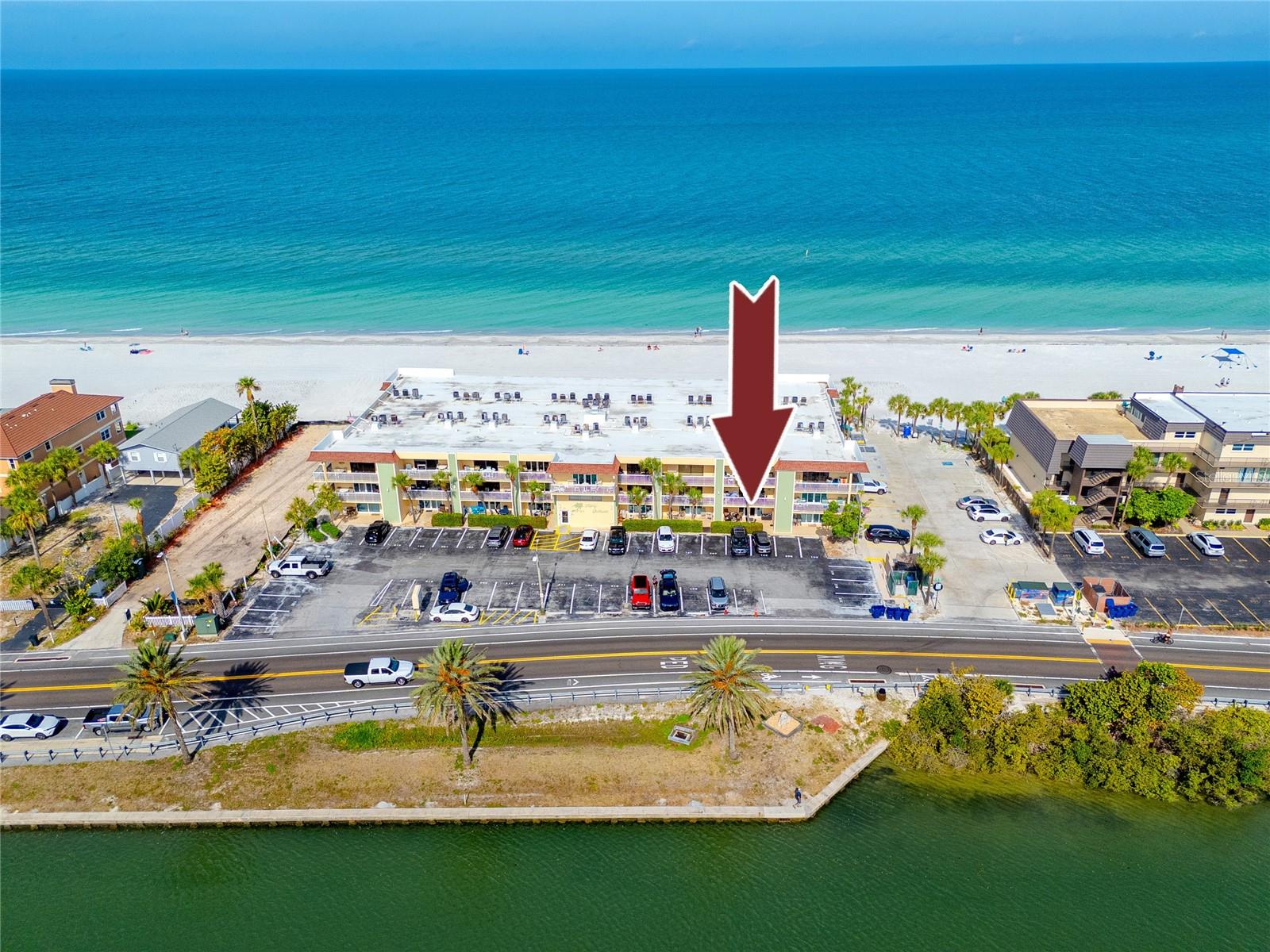 Location is everything with this Indian Rocks Beach condo, where water frames the building on both sides. The Gulf of Mexico positions the beach as your backyard, while the covered front porch looks out over the Intracoastal Waterway.
Inside, the 1,008-square-foot two-bedroom, two-bath layout is open and easy to move through, with easy-to-maintain ceramic tile in the  living areas, solid wood, custom cabinets, and Corian counters anchoring the kitchen with BRAND NEW appliances. A breakfast bar connects the kitchen to the living and dining area without breaking the flow. The master bedroom and bathroom has a walk-in tiled shower, new commode, new vanity, sink, and lighting; the second bath adds dual sinks and a tub with shower.
Additional on-site storage include a locked owner's closet inside the unit and a locked owner's storage area on the porch. 
In recent years the building has seen a $2 million renovation covering the balconies, railings, concrete, paint, and pool deck. The heated community pool now sits on updated decking beachside, with grill stations and outdoor seating steps from the surf. The building includes an elevator, a common area laundry room, and one assigned parking space right outside the unit's front porch.
Fifty Gulfside allows short-term rentals with a five-day minimum, positioning this as a viable income-producing asset in one of Pinellas County's most consistent beach rental markets. An on-site management company is available to handle bookings and guest services, or owners can self-manage with current rental projections showing $60,000 to $65,000 for next year. The $913 monthly fee covers cable, internet, water, sewer, trash, pest control, pool maintenance, exterior maintenance, grounds, and building insurance, keeping carrying costs clean for investors and owner-occupants alike.
Indian Rocks Beach sits mid-corridor on Gulf Boulevard, within reach of waterfront dining, Clearwater Beach to the north, and St. Pete/Clearwater Airport approximately 20 minutes east. Tampa International is roughly 35 minutes via the Courtney Campbell.