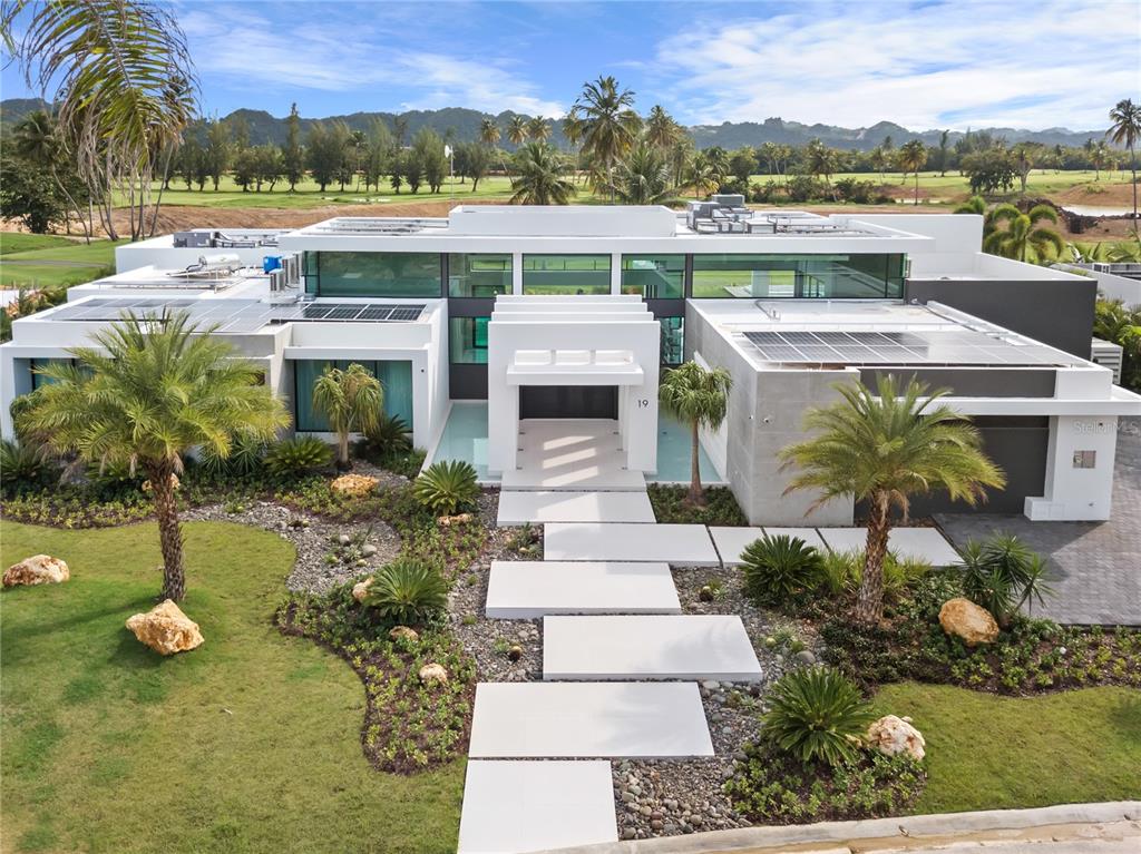 Featured in Architectural Digest Spain and design magazine Modo de Vida, this stunning contemporary home was designed for a lifestyle of leisure. Just steps from the DB Clubhouse, this property has 5 spacious bedrooms, 4 full baths, 2 half baths, and top of the line entertainment facilities, including a heated pool, outdoor bar, wine cellar, and golf simulator.

Premium landscaping features such as dual fountains at the entryway and designer lighting across the yard make this home stand out amongst others in the area. An upgraded driveway leads to a spacious garage with more than enough room for two cars and two golf carts, plus plenty of storage.

The floor plan is designed to maximize views of the nearby golf course and surrounding mountain scenery. With 18” ceilings and floor-to-ceiling windows, the home is filled with natural light.

This home boasts the finest European finishes throughout. Spanish porcelain tile flooring gives a beautiful marble effect with improved durability, and in the kitchen, custom Italian cabinets create a modern minimalist aesthetic, whilst an oversized island with two waterfalls adds a sense of grandeur.

Wine enthusiasts will appreciate the temperature- and humidity-controlled cellar, whilst the Trackman Simulator will appeal to keen golfers. At the rear of the property, this home has a large, heated swimming pool with a sun shelf and spa pool, a gas fire pit, and a full-sized outdoor bar with an 85” TV and luxury grill. 

No expense has been spared to future-proof this home, with custom-programmed Vitrea light switches, top of the range sound system, and ACMaster installed throughout the home. 100 40kw solar panels have been installed on the roof, with a 13.5kwh Tesla Powerwall and backup generator to provide almost a week’s worth of power.