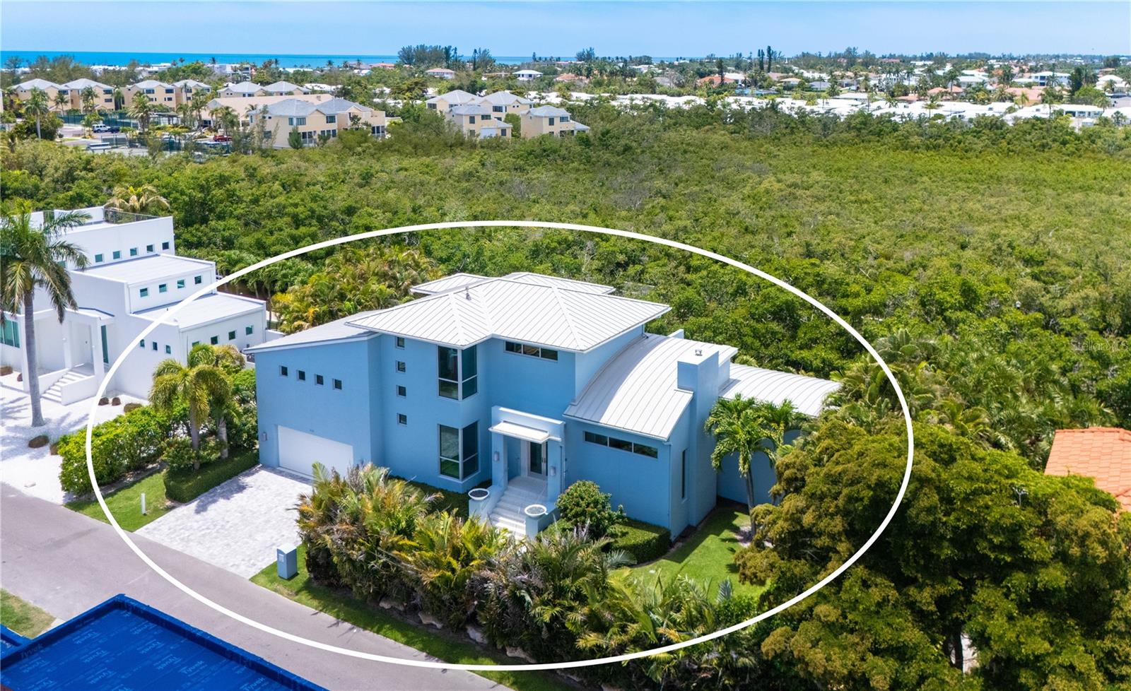 Tucked away on the coveted north end of Longboat Key, this custom-designed coastal contemporary residence offers a rare blend of modern architecture, boating access, and waterfront living. Designed by architect Mark Sultana of DSDG, the home was completed in 2011. Positioned along a protected saltwater canal with private dockage and just moments from the Gulf's sandy shoreline, this island retreat captures tranquil water views, tropical surroundings, and spectacular sunsets from multiple levels.
Spanning nearly 3,100 square feet, the four-bedroom layout is designed for effortless indoor-outdoor living. The main level serves as the heart of the home, where soaring 18-foot whitewashed cypress ceilings crown the open great room. A contemporary gas fireplace with gray glass tile anchors the living area, while walls of impact-rated glass fill the residence with natural light and frame views of the canal and lush mangroves beyond. The open-concept design seamlessly connects the living room, dining area, and gourmet kitchen, creating an ideal environment for both entertaining and everyday enjoyment.
The chef's kitchen is appointed with custom solid-wood cabinetry by Campbell Designs, quartz countertops, glass tile backsplash, breakfast bar, oversized pantry, water filtration, and premium appliances. Thoughtful details such as Lutron lighting system, built-in audio throughout the interior and exterior, impact-rated doors and windows, soft-close drawers, metal barrel roof, propane-fueled pool heater and outdoor grill, oversized two-car garage with workshop, abundant storage, and dedicated kayak storage enhance both function and style.
An open staircase crafted from powder-coated aluminum with blonde maple treads creates an architectural focal point while connecting the living spaces. The second level is devoted to private accommodations, highlighted by the primary suite featuring dual walk-in closets, a private waterfront terrace, and spa-inspired bath with freestanding soaking tub, marble-topped dual vanity, oversized glass shower, and separate water closet. Two additional guest bedrooms share a beautifully appointed bath, with one currently configured as a den.
Adding exceptional flexibility, a detached cabana suite overlooks the pool deck and serves as a private guest retreat. Complete with a full bath, walk-in closet, morning kitchen, and separate entrance, this space functions perfectly as a fourth bedroom, guest quarters, home office, or artist's studio.
Outdoor living is equally impressive. White terrazzo terraces on each floor overlook the 36-foot lap pool and spa with waterfall feature, creating a private tropical setting enhanced extensive landscape lighting, mature exotic foliage, and lush zoysia grass. The private IPE wood dock includes an 8,000-pound lift, kayak launch, water and electric service, and underwater lighting for boating enthusiasts. 
Located on one of Longboat Key's most desirable stretches, residents enjoy easy access to the island's pristine Gulf beaches, waterfront dining, marinas, and scenic biking paths. The Longboat Key Club's golf and tennis facilities are nearby, while St. Armands Circle offers boutique shopping and acclaimed restaurants just minutes away. Downtown Sarasota's cultural attractions are easily accessible, creating an exceptional coastal lifestyle that blends privacy, recreation, and convenience.