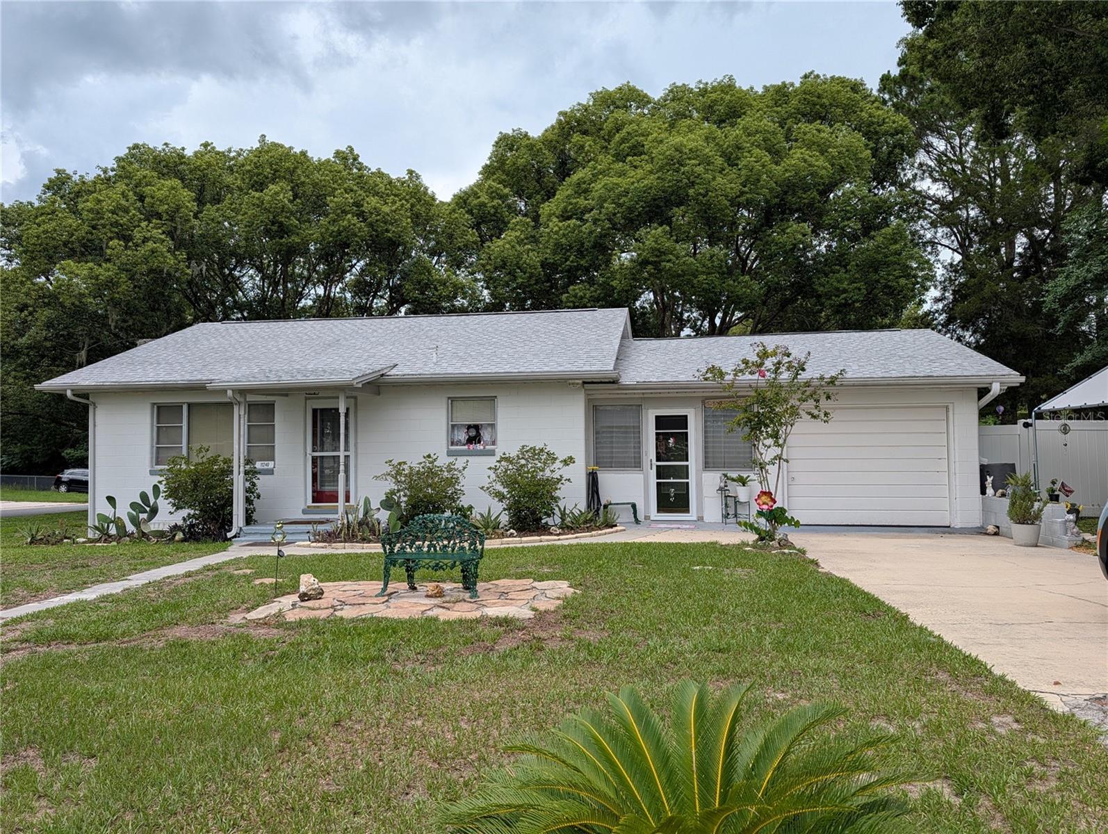 Welcome home to this charming concrete block ranch nestled on a spacious corner lot in Belleview! Built in 1957, this well-maintained 2-bedroom, 2-bath home blends timeless character with thoughtful updates and plenty of room to enjoy both indoors and out.

Step inside to find a comfortable floor plan featuring a generous living room, separate dining area, and an oversized enclosed bonus room that offers endless possibilities for a hobby space, home office, reading room, or additional gathering area. Charming architectural details, including arched openings and vintage character throughout, add warmth and personality rarely found in newer homes.

The kitchen offers abundant cabinet storage, updated flooring, and newer appliances, including a refrigerator and range that are approximately one year old. The primary bathroom has been beautifully updated with a spacious walk-in shower, while the washer and dryer are approximately two years old and are included with the sale.

Outside, you'll appreciate the fully fenced backyard shaded by a magnificent mature oak tree, along with a storage shed for tools and equipment. The riding mower conveys, making lawn maintenance even easier.

Major updates include a roof installed in 2020. The attached garage provides additional storage and workspace, while public utilities and a convenient Belleview location place shopping, dining, medical facilities, and everyday conveniences within easy reach.

Whether you're looking for your first home, downsizing, or searching for a property with solid construction and room to make it your own, this Belleview gem is ready for its next chapter.

Schedule your private showing today!