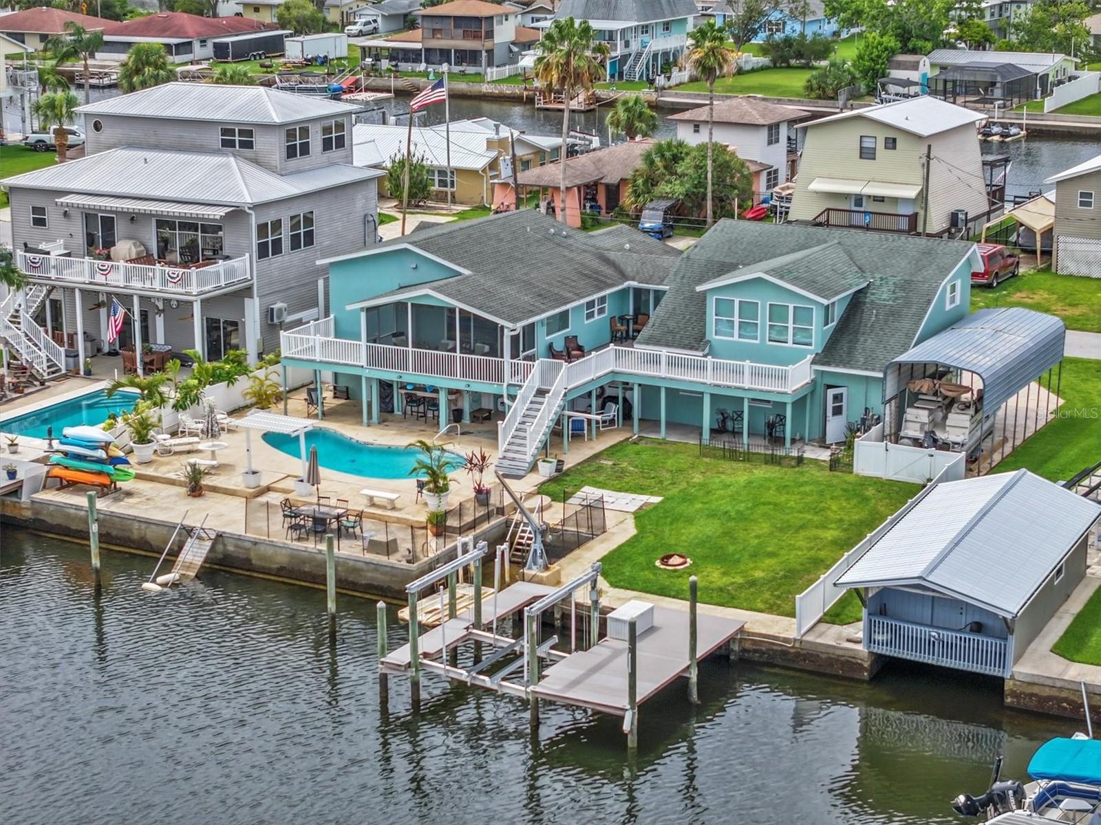 This unique multigenerational single family pool home has 7 bedrooms and 5 bathrooms home with 4 separate units for different family members. Unit 1 is the “owner’s suite” on the second floor with 2 bedrooms and 2 bathrooms with full kitchen with granite island/countertops and stainless-steel appliances. Additional features include wood flooring, updated bathrooms, screened porch with Gulf views and spa tub in the master bathroom.  Unit 2 is on the second floor with 2 bedrooms and 1 bathroom with a full kitchen and living room with Gulf Views. Downstairs on the ground level is Unit 3 with 2 bedrooms and 1 bathroom, and Unit 4 is a 1 bedroom and 1 bathroom unit as well as a large garage/storage/workshop. Understand that the ground level build out is not covered by flood insurance. Brand new mental roof was just installed in June of 2026. This unique design allows family members to live their own lives within this communal property. 

The backyard has 93 feet on a saltwater canal that leads directly to the Gulf of Mexico without any fixed bridges. For those family members that love water. The property has a 10,000-pound boat lift and Duratek fixed dock as well as a large inground gunnite pool with oversized stamped concrete deck, and large grass area for the family members with fur. Cover parking spot for your boat or RV. 

This home is in the Direct Gulf Access section of Hernando Beach meaning the canals behind this home are saltwater, gracefully rising and falling with the tides. This means that you enjoy seamless navigation directly to the Gulf of Mexico without encountering fixed bridges or any obstructive challenges. The convenience and freedom of unimpeded boating make this section highly sought-after for those who crave an optimal boating experience.

This section of Hernando Beach does not have an HOA meaning no deed restrictions only county does apply. So, you can keep boats, trailers, and commercial vehicles in your yard or driveway. You can have 8-foot-high privacy fences and use your home as a short-term rental if you want. This section is the most popular place to live in Hernando beach because it is the best for boating.

Welcome to Hernando Beach, a hidden gem nestled along the Gulf of Mexico, where the heart of the community beats to the rhythm of recreational fishing and boating. Tucked away down a coastal 2-lane highway with access points only from the North and South, Hernando Beach is a quiet and isolated coastal hamlet offering a unique blend of tranquility and vibrant coastal living.

While the name might suggest sandy shores, Hernando Beach surprises with its lack of a traditional beach, compensating instead with a cool coastal vibe that permeates through waterfront tiki bars, marinas, fine dining restaurants, seafood markets, and charming shops. The community is a haven for those seeking a waterfront lifestyle, with single-family homes lining saltwater direct Gulf Access canals or freshwater indirect Gulf Access canals.

In essence, Hernando Beach beckons those who yearn for an extraordinary Gulf Coast Fishing Homes Lifestyle, where the rhythms of the sea and the charms of coastal living converge in perfect harmony. Welcome to a community where isolation feels like a luxury, and the beauty of the Gulf Coast unfolds in every tide and sunset.