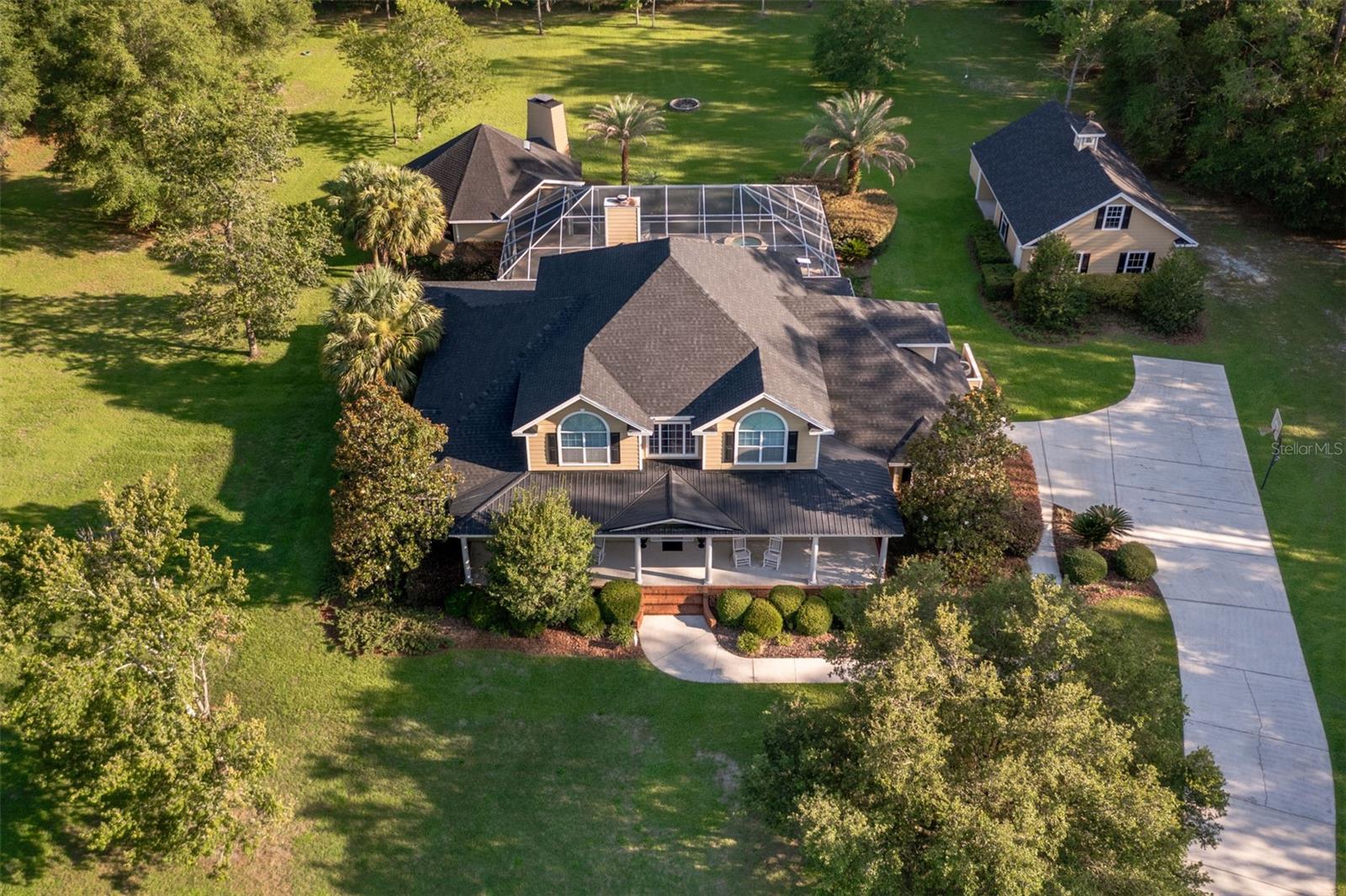 Welcome to Southern living at its best. This exceptional custom-built estate is nestled on 7.33 picturesque acres. Surrounded by mature trees and beautifully established landscaping, this private retreat offers the perfect blend of luxury, comfort, and Florida outdoor living.

Built in 2007, this impressive 4-bedroom, 4-bathroom home features 4,013 square feet of heated and cooled living space and an expansive 8,005 square feet under roof. Designed for both everyday living and entertaining, the thoughtfully crafted floor plan includes a spacious bonus room, walk-in attic storage, and generous living areas throughout.

Step outside to your own resort-style oasis featuring a screen-enclosed pool and spa, expansive lanai, and an incredible outdoor living area complete with a summer kitchen, bar, fireplace, and comfortable gathering space—perfect for hosting family and friends year-round.

Recent updates provide peace of mind, including a new roof in 2026 and a 2022 HVAC system. The sprawling acreage offers privacy, natural beauty, and room to enjoy the tranquil surroundings while remaining conveniently located near Alachua, Gainesville, and area amenities.

This  Santa Fe Forest property delivers the best of luxury country living with modern conveniences, stunning outdoor spaces, and exceptional craftsmanship. Don't miss the opportunity to make this remarkable estate your own.
