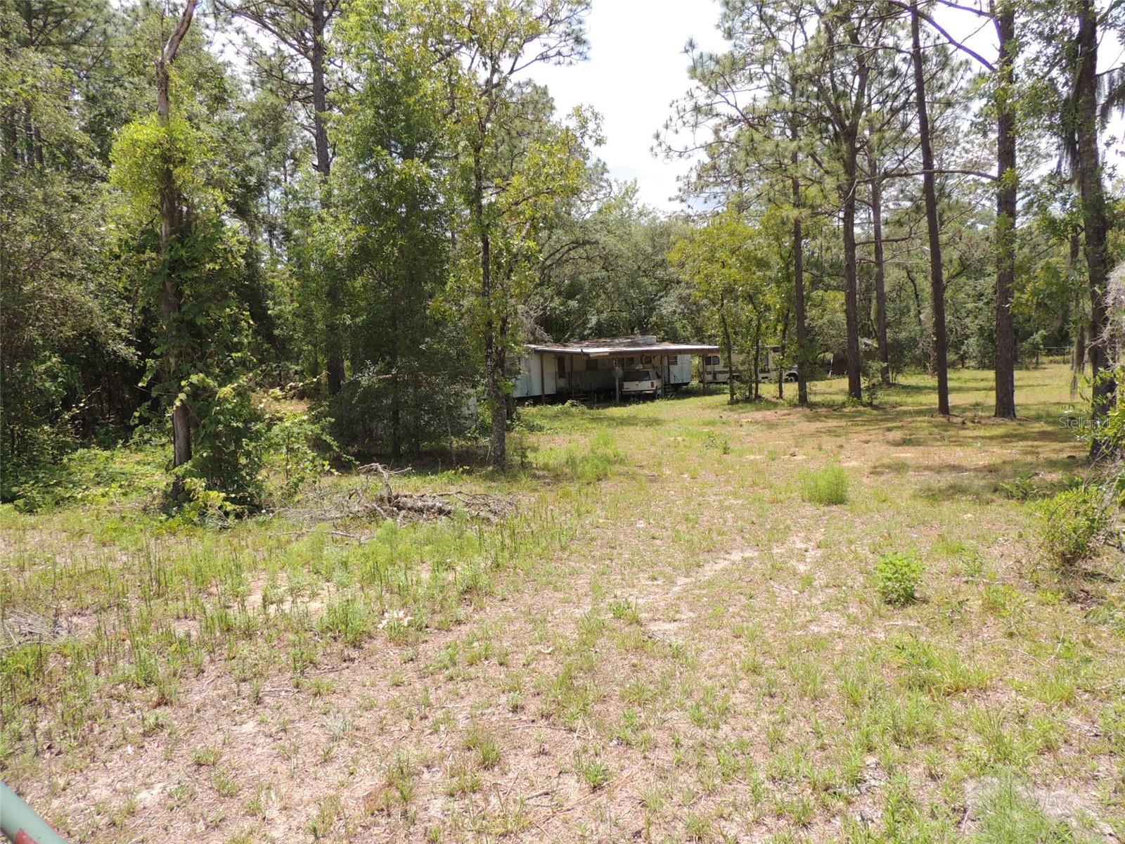 COUNTRY LIVING WITH ROOM TO GROW ON 3 ACRES! This unique property offers the perfect blend of privacy, flexibility, and opportunity. Situated just one block off a paved road, the property consists of three separate 1 acre parcels—two of which are desirable corner lots—providing excellent access and future potential.

The existing 2 bedroom, 1 bath single-wide mobile home features an attached carport and is ready for comfortable country living or a rental opportunity. The entire property is perimeter fenced, making it ideal for pets, livestock, or simply enjoying your own private space.

What truly sets this property apart is the additional homesite already in place. One of the extra lots is equipped with its own 4" well, septic system, and power pole, along with a small shop/storage building and a pole barn—perfect for extended family, a second residence, or income-producing potential.

Whether you're looking for a multi-generational setup, investment property, or a peaceful homestead with room to expand, this property offers endless possibilities in a quiet rural setting. Don’t miss this rare chance to own acreage with built-in flexibility!