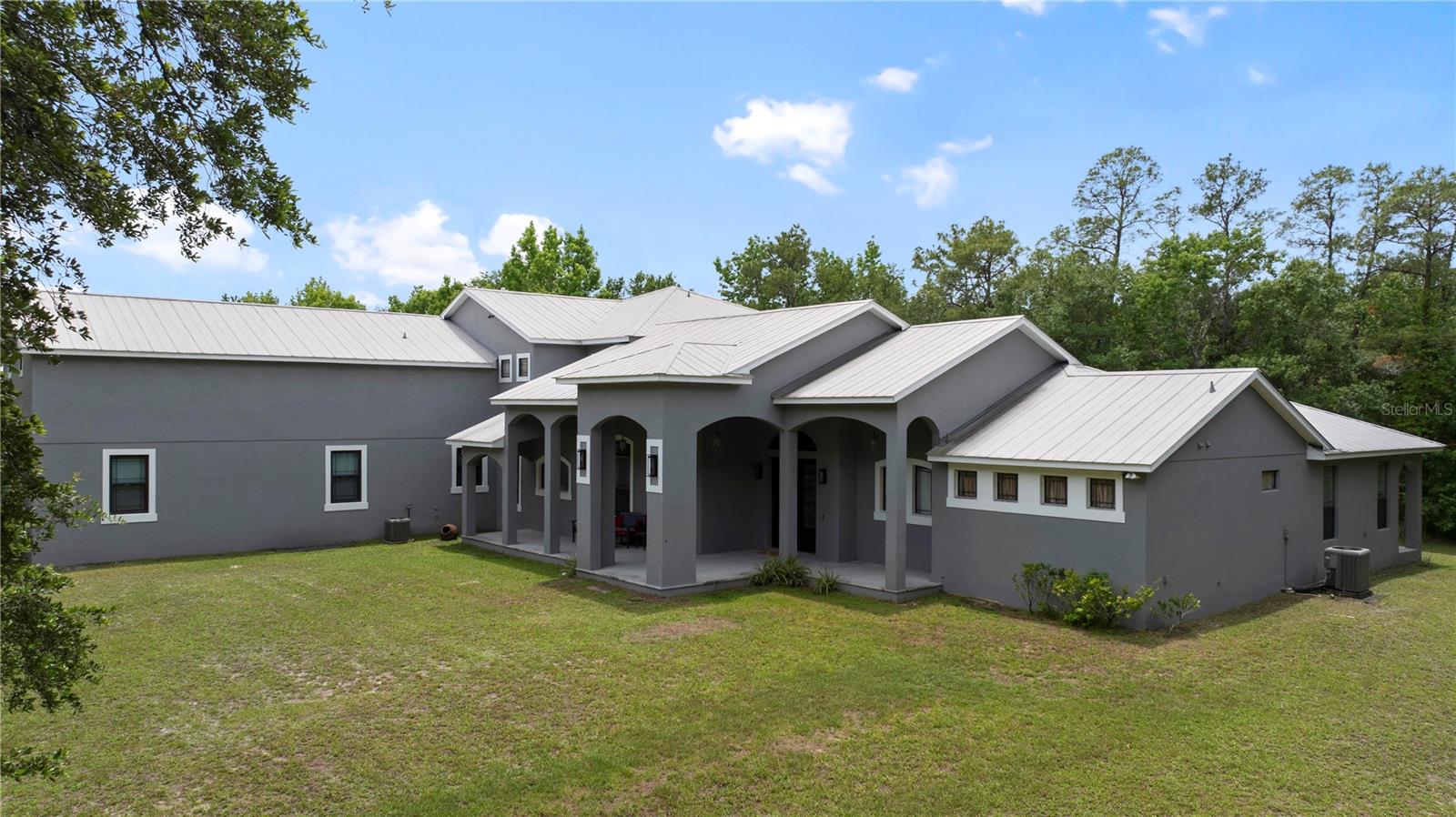 On over 2.5 private acres in the sought-after community of Wedgefield, this exceptional estate offers a rare blend of luxury, privacy and convenience. Behind a long tree-lined driveway and surrounded by mature woods, the property creates a tranquil, nature-inspired retreat while remaining just 20 minutes from Lake Nona, Medical City, Orlando International Airport and approximately 30 minutes from Orlando’s world-renowned attractions. Spanning more than 5,400 square feet, the residence showcases soaring vaulted ceilings, abundant natural light, and a thoughtfully designed floor plan ideal for everyday living and entertaining. The private first-floor primary suite occupies its wing of the home and features wood flooring, dual walk-in closets, private patio access and a spacious spa-inspired bath. At the heart of the residence, the gourmet kitchen offers 42-inch cabinetry, granite countertops, an oversized island with vegetable sink, stainless steel appliances, beverage refrigerator, walk-through butler’s pantry, separate walk-in pantry and breakfast nook framed by picturesque views of the surrounding landscape. Upstairs, three additional bedrooms are complemented by generous flex spaces, including a massive bonus room and dedicated office, providing endless possibilities for remote work, a fitness studio, game room or multi-generational living. Two of the bedrooms enjoy direct access to an expansive 35-foot balcony overlooking the private grounds and peaceful wooded backdrop. Designed for those who value space, privacy and lifestyle, the estate also features a private pond and an impressive 60-by-35-foot detached workshop complete with oversized doors, a climate-controlled workspace, additional flex room ideal for a gym, and extensive covered parking for RVs, boats, recreational vehicles or an automotive collection. With no HOA and endless room to enjoy the outdoors, this is a rare opportunity to own one of Central Florida’s unique luxury lifestyle properties, where nature, privacy and convenience exist in harmony.