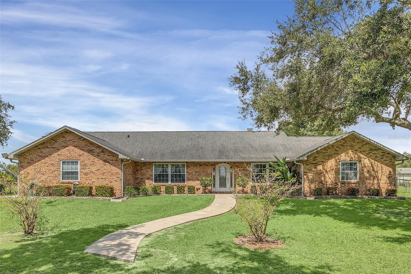 This property has it all! 2.50 Acres with a 3 bed/2 bath pool home and a 2016 1 bed/1 bath Guest House. The main house is 3250 total sq. ft. and the guest house is 968 sq. ft. with a total of 4218 sq. ft. Both of these homes have real brick exteriors. The sunken living room has a beautiful wood burning brick fireplace, high ceilings and Italian Porcelain Tile. There's a beautiful salt water sports pool with a spa and heater. In the kitchen you'll find a dinette area and a kitchen island. It has Level 4 Granite countertops and custom hickory kitchen cabinets. The kitchen has a breakfast bar with seating for 8. The main house has been updated with double pane windows, new plumbing, new water softener, water heater, real wood floors, Italian Porcelain tile, custom blinds, French doors, custom crown & molding, custom toilet and porcelain tub in the Master bath, and seamless gutters with leaf guards. The septic drain field was replaced in 2016 and the roof on both homes are only 7 years old. The Guest House has custom hickory kitchen cabinets with granite countertops, custom blinds, and custom crown and base molding. The property has a Swan security system with cameras and a monitor. The fire alarm system is connected to both homes so if one goes off they all go off. It has a 2 car garage with a new garage door opener and camera. There is a stand alone 12x20 carport, 10x20 small shed, 12x24 large shed with AC, and a 20x32 Big Shop. The property is beautifully landscaped with lots of fruit trees including Mango, Papaya, Peach, Pomegranate and Star Fruit. The property behind the home and across the front is fenced with chain link, and it has an electric gate at the entrance. It also has a cross fence behind the home so there's plenty of room for your animals. Perfect location to everything, only 8.5 miles to the Orlando Airport, 6.5 miles to Lake Nona, 8.7 miles to the FL Turnpike, and Austin Tindall Park is right across the street. All measurements are approximate.