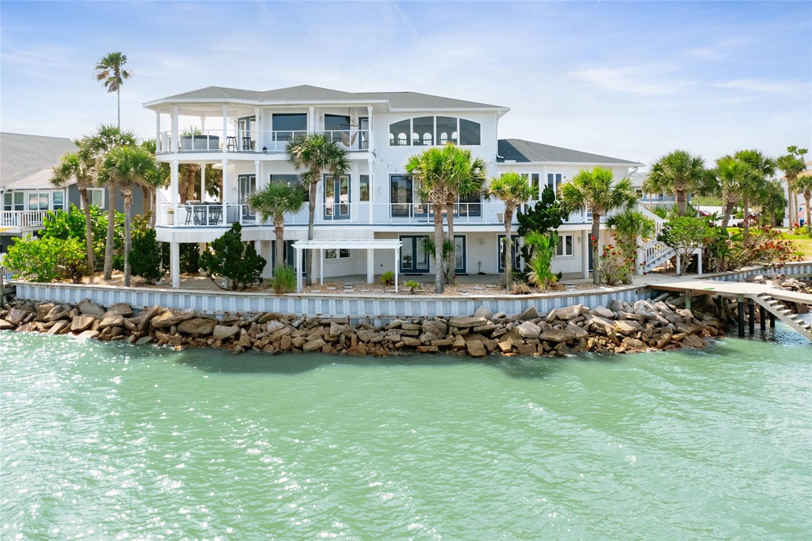 A place like no other! Step into a world of unparalleled serenity and opulent living with this exquisite waterfront estate, ideally positioned where the Matanzas inlet, the Atlantic Ocean, and the Intracoastal Waterway converge. Every day feels like a vacation at a five-star resort with this stunning property, meticulous custom design to capture every moment of natural beauty. Enjoy breathtaking views that sweep across the merging waters, perfect for boating, fishing, and a day at your private beach. Designed for those who demand the best in life, indulge in the luxury of your own private retreat where elegance meets tranquility—your dream home awaits, enveloping you in a panorama of beauty and peace. Featuring 4,538SF with 5 bedrooms, 3.5 bathrooms plus over 2,000SF of exterior porches/decks, soaring ceilings, expansive living and dining areas all with picturesque water views! From the coastal etched double glass entry door your eyes are drawn to the water through the wall of windows and glass doors lead you to 1 of 4 expansive decks where you will find yourself spending all your time! On the main level, the kitchen is a chef’s delight with a double oven, gas range, built-in microwave, and easy loading elevated dishwasher. A breakfast bar with seating extends into the family room for your extra guests and an extra bank of cabinets with a wine cooler. The dining room is set apart and complimented by a one of a kind oyster shell chandelier illuminating the table. Right off the kitchen, enjoy sunset dining on the covered deck with a convenient built-in grill and green egg. On the other end of the home is a half bath for guests and a guest bedroom with en-suite bath and doors to the deck. Head up the stairs to the master suite where your first stop will be the landing with panoramic water views. This may become one of your favorite spots to drink your morning coffee or read a good book. The master bedroom features a tray ceiling and yet more picturesque views from your bed. Double doors lead to your own private oasis with a hot tub to soak in while star gazing at the end of your day. The master bath is its own sanctuary with a jetted soaking tub, walk in shower, dual vanities and large closet. An additional bedroom that can be used as an office is just off the master bathroom with a private deck. On the lower level of the home is the perfect spot for all of your guests with 2 additional guest bedrooms and a shared european style bathroom with access to the outdoors. An oversized flex room can be used as a gym, an additional family room, or a hobby space. The possibilities are endless with this space. Each floor of this multi-level home boasts outdoor decks, offering sweeping views that capture the natural beauty of the surrounding landscapes. For boating enthusiasts, the property is a paradise including a private boat dock and lift, making it easy to set off for a day on the water or enjoy spontaneous nautical adventures off shore. At low tide, you have the ideal private beach to wade in and let the kids play or launch the kayaks and paddle boards. Across the waterway is a preserved beach so your views will never change. The oversized 2 car garage offers plenty of extra storage space, a door to the dock and outdoor shower as you come in from a day on the water.  Whether entertaining guests or seeking a peaceful retreat, this home is a true sanctuary where every element has been crafted for an exceptional living experience. Welcome home!