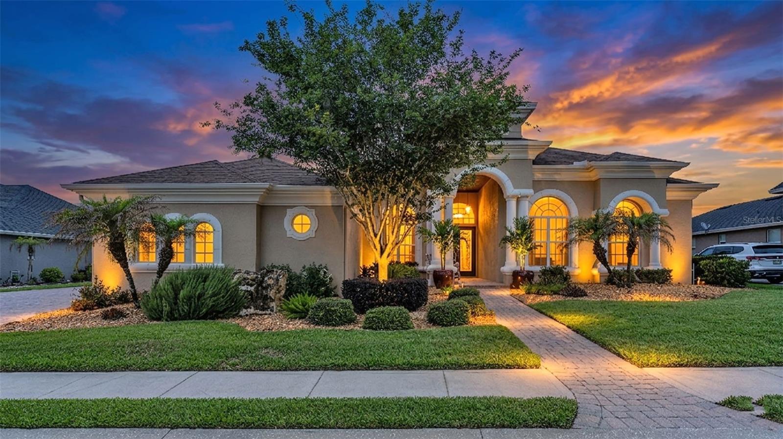 Welcome to the much sought-after, exclusive gated golf community of Eaglebrooke, featuring 24/7 guarded security and exceptional country club living in South Lakeland! This immaculately maintained custom Rutenberg-built St. Augustine plan is perfectly positioned on the seventh tee, offering sweeping golf course views and an exceptional blend of elegance, comfort, and everyday livability.

This light, bright, and open pool home features 3 bedrooms, 3.5 bathrooms, a private office, and a spacious bonus/flex/theater room designed to accommodate today’s lifestyle. Thoughtfully designed to embrace natural light and picturesque views, the main living areas seamlessly connect indoor and outdoor living while overlooking the sparkling pool and manicured fairway.

Gracious formal living and dining rooms welcome you with refined architectural details including crown moulding, decorative niches, rounded corners, statement tray ceilings with custom millwork detail, and beautiful architectural millwork surrounding doors and windows. A wood-burning fireplace adds warmth and character to the formal living room, while triple sliding glass doors frame beautiful views and open to the entertainment-sized lanai and pool area.

At the heart of the home, the spacious kitchen is designed for both everyday living and entertaining, featuring wood cabinetry, granite countertops, stainless steel appliances including a cooktop, built-in oven, and microwave, a large center island with seating, and a casual café-style dining area. The kitchen flows effortlessly into the expansive great room, where triple sliding doors open to the covered lanai, sparkling screened pool with waterfall feature, and outdoor entertaining spaces. A double trey ceiling and a custom tropical leaf-blade ceiling fan adds a distinctive design touch to the great room.

The exquisite primary suite is a true retreat, offering generous space for a sitting area, beautiful bay windows overlooking the pool and golf course, and a luxurious ensuite bath featuring dual walk-in closets, linen storage, tall dual vanities with wood cabinetry and granite countertops, a dedicated makeup area, jetted soaking tub, walk-in shower, and private water closet.

At the front of the home, the private office enjoys convenient access to a nearby powder bath, ideal for working from home or guest use. The spacious bonus/flex/theater room offers additional living space and is located near a full bath with walk-in shower, making it ideal for guests, hobbies, or multi-generational living. Two additional bedrooms share a Jack-and-Jill bath featuring dual sinks, an undermount vanity, and tub with shower.

Additional highlights include a security system, window shades throughout, lush professional landscaping, paver front porch, oversized side-entry 3-car garage with room for your golf cart, exterior paint completed in 2025, and a roof replacement in 2022.

Residents of Eaglebrooke enjoy a guarded gated entrance, golf, clubhouse, restaurant, community pool, and convenient access to shopping, dining, hospitals, recreational amenities, and the Polk Parkway for an easy commute to Tampa or Orlando.