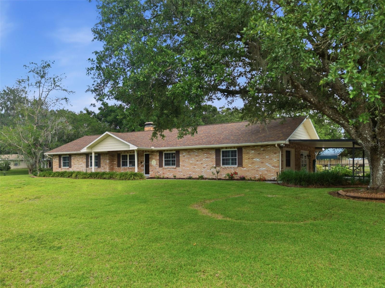 Tucked away on 1.56 privately fenced acres along the scenic Old Fort King Trail, this exceptional ONE-STORY BRICK estate offers the perfect blend of lifestyle, space, and convenience. NO HOA and NO FLOOD INSURANCE required. Zoned AG1, this is a home where your animals large and small are welcomed. Featuring 4 bedrooms, 3 bathrooms, a sparkling pool, and an incredibly versatile floor plan, this property was designed for both everyday comfort and unforgettable entertaining. The meaningful updates and improvements have been completed, including a new roof, new HVAC system, new well pump, upgraded water system from Just Water, new rear fencing, and annual termite inspections for added peace of mind.
 
The peaceful, park-like setting invites you to slow down and stay awhile while allowing the flexibility of your personal needs andcreativity. Inside, the open concept incorporates an expansive great room anchored by a stunning floor-to-ceiling stone wood-burning fireplace — the perfect backdrop for cozy evenings or gathering with friends and family. The great room opens onto the dining area and heart of the home beautifully appointed kitchen. Thoughtfully designed with custom solid wood 42” cabinetry with crown molding, soft-close drawers and pull-out shelving, gleaming granite countertops, a center island, oversized breakfast bar, and views overlooking the sprawling backyard and pool area.
Large 24x24 tile flooring throughout creates a seamless, low-maintenance living experience. The flexible layout offers endless possibilities, including an option for a private 4th bedroom suite with exterior access and an ensuite bath. This space is also ideal for multi-generational living with a separate entry, a home office, guest retreat, or game room. French doors open from the great room onto the Florida room and screened pool area, designed for  year-round outdoor living. The pool area is complete with a full outdoor shower, dressing area and half bath. A separate outdoor kitchen ready for your grill and smoker! A recently constructed covered 20’x30’ pavilion adds even more functional outdoor gathering space overlooking the expansive backyard.
The rear separately fenced portion of the property features a massive 30’x40’ slab, and double entry gate offering endless opportunities for RV parking, a tiny home, workshop, additional garage, or the ultimate custom “man cave”or “glamping” area. Don’t miss this unique opportunity for country living that is close to everything. Welcome home!