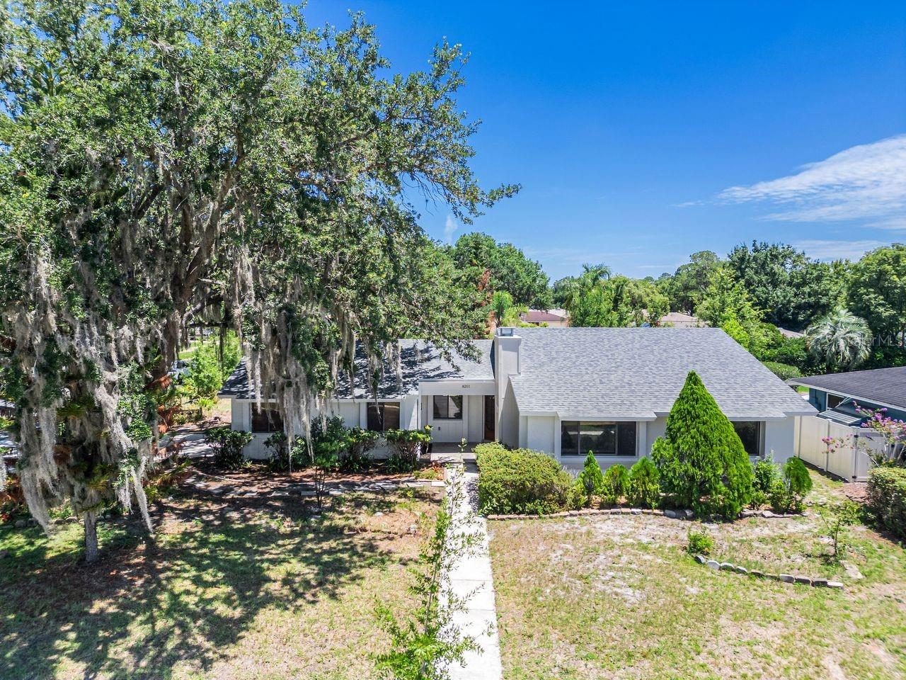 Beautifully reimagined and move-in ready! Welcome to this stunning 3-bedroom, 2-bath home offering approximately 1,477 square feet of thoughtfully updated living space on an oversized 0.28-acre corner lot with NO HOA. Surrounded by magnificent mature oak trees, this property offers exceptional curb appeal, shade, and privacy. Inside, you'll find soaring ceilings, abundant natural light, luxury vinyl plank flooring throughout, fresh interior and exterior paint, and an open-concept layout designed for comfortable everyday living. The beautifully remodeled kitchen features modern cabinetry, quartz countertops, stainless steel appliances, and a spacious island overlooking the main living areas. Both bathrooms have also been tastefully renovated with elegant, contemporary finishes. A striking wood-burning fireplace with vaulted ceilings creates a warm and inviting focal point, adding character and architectural charm to the family room. Step outside and enjoy the oversized corner lot with endless possibilities for entertaining, gardening, or creating your own outdoor retreat. The roof was replaced in 2021, providing added value and peace of mind. Conveniently located in East Orlando with easy access to SR-408, SR-417, Orlando International Airport, Downtown Orlando, UCF, Valencia College, shopping, dining, and more. Beautifully updated, full of character, and situated on a spacious lot with no HOA—this is a home you won't want to miss. Schedule your private showing today!