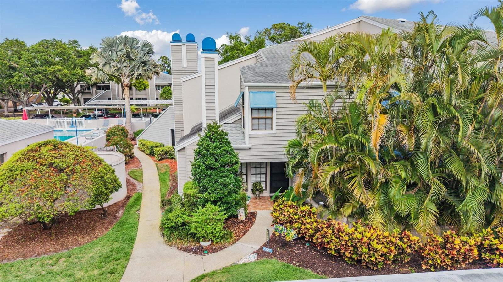 Welcome to this beautifully maintained 2-bedroom, 2-bath condo located in the desirable Bardmoor community of Seminole. This spacious two-story residence offers an inviting blend of comfort, style, and functionality with soaring vaulted ceilings, abundant natural light, and thoughtfully designed living spaces throughout.

Step inside to a bright and airy living room featuring dramatic mirrored accent walls, a cozy fireplace, and large windows with plantation shutters that enhance the home's elegant feel. The updated kitchen showcases white cabinetry, stainless steel appliances, generous counter space, and modern finishes, creating a clean and timeless look perfect for everyday living and entertaining.

The versatile floor plan includes spacious bedrooms with ample closet space, including a private primary suite with an en-suite bath. An additional loft-style upper level adds character and flexibility for a home office, reading nook, or guest space. Sliding glass doors lead to a private outdoor patio area surrounded by lush tropical landscaping, offering the perfect spot to relax and unwind.

Residents enjoy beautifully maintained grounds and resort-style amenities including a community pool and spa. Conveniently located near Bardmoor Golf & Tennis Club, shopping, dining, parks, and just a short drive to the Gulf beaches, this condo combines low-maintenance living with an ideal Seminole location.