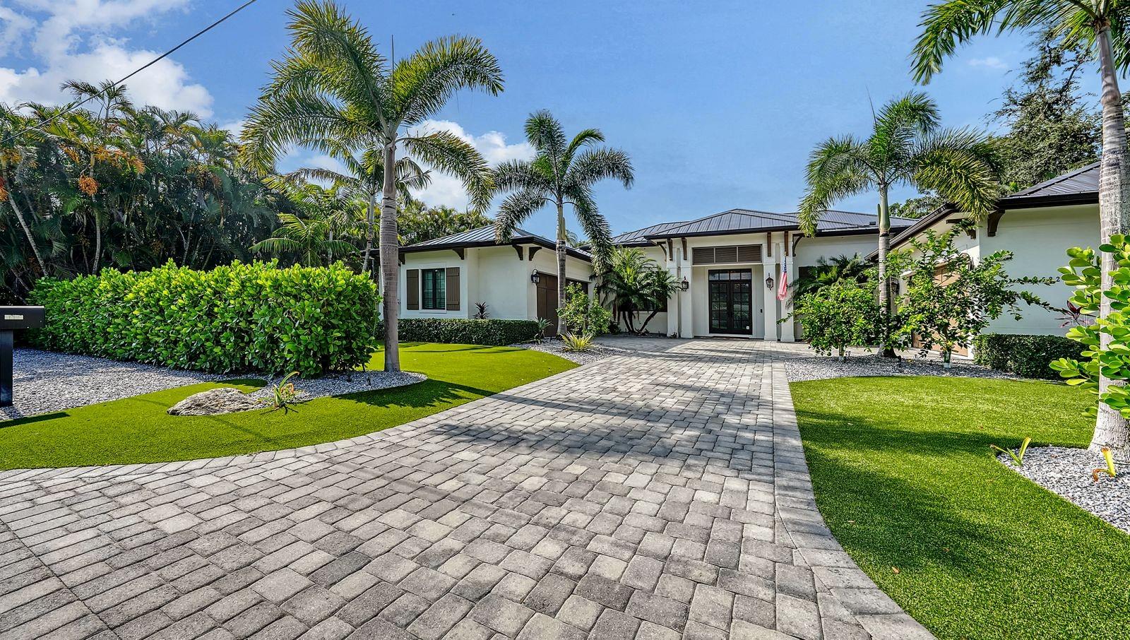Located West of Trail near the historic Field Club, this stunning residence is a refined interpretation of British West Indies architecture,
 offering over 4,000 square feet of thoughtfully designed single-level living. Set on an estate lot, the home blends timeless coastal elegance with exceptional craftsmanship and seamless indoor–outdoor flow. A dramatic great room welcomes you with vaulted wood ceilings, fireplace, and expansive pocketing sliders that frame views of the lushly landscaped pool and spa. The open-concept design flows effortlessly into the chef’s kitchen, appointed with premium Thermador and Wolf appliances, custom solid-wood cabinetry, quartz surfaces, and an oversized island—perfectly complemented by a separate dining area and custom dry bar with wine refrigeration. Designed for both privacy and versatility, the residence features four en-suite bedrooms, office, and a spacious TV lounge or bonus room that opens directly to the outdoor living areas. The private primary suite is a serene retreat with a vaulted wood ceiling, dual walk-in closets, and direct access to the covered lanai. Its spa-inspired bath showcases dual vanities, a soaking tub, and an expansive glass-enclosed shower. Outdoor living is a true centerpiece, with a generous travertine lanai, fully equipped outdoor kitchen, dining verandah, and a large gas- and electric-heated saltwater pool and spa with waterfall—ideal for entertaining or quiet relaxation amid tropical landscaping and architectural lighting. Additional highlights include hurricane-rated impact windows and doors, a whole-house generator, brand new metal roof, dual on-demand water heaters, an expansive paver motor court, low maintenance & fenced yard, and a rare four-car garage configuration, including an owner’s garage with EV outlet and climate control. Ideally located minutes from Siesta Key, Southside Village, Sarasota Bay, and downtown Sarasota, this exceptional home offers privacy, design integrity, and proximity to the best of the Sarasota lifestyle