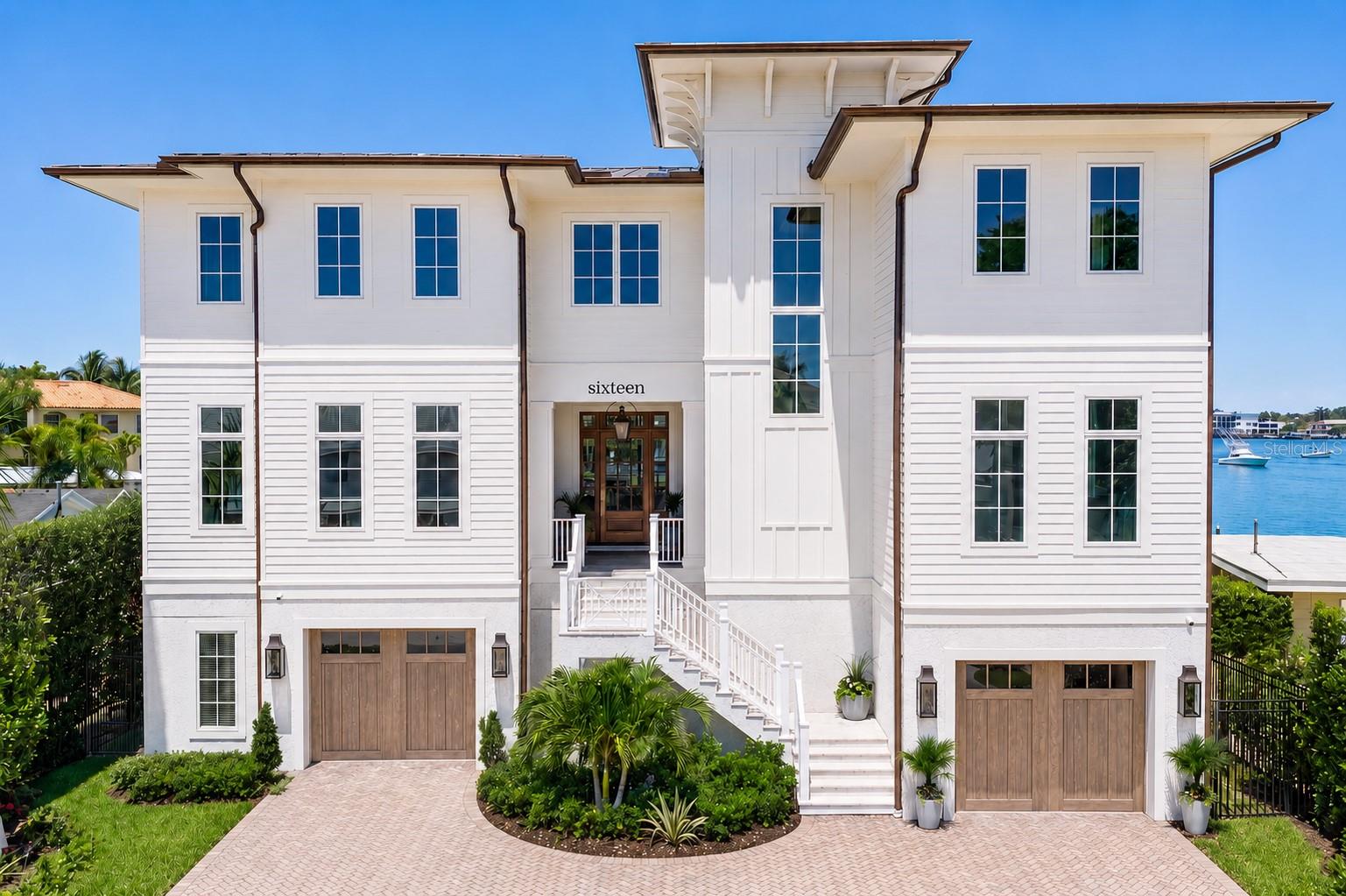 Nestled in Tampa’s coveted Beach Park neighborhood, this new-construction Southern Living Showcase Home blends timeless coastal architecture with refined modern luxury. Positioned on a waterfront homesite with beautiful open bay views, the residence was thoughtfully designed to maximize natural light, indoor-outdoor living, and everyday functionality. Built on pilings with breakaway walls, all-block construction, and a finished living level at over 17’, the home offers an elevated approach to coastal living with both beauty and peace of mind. As a Southern Living Showcase Home, the residence carries the added distinction of being aligned with a respected custom-home program known for craftsmanship, regional expertise, and timeless Southern design. The Southern Living Custom Builder Network includes more than 80 selected builders across the South and connects members with design resources, industry programming, and nationally recognized product partners. From the moment you arrive, the craftsmanship is evident, with James Hardie exterior detailing, a metal roof, Pella windows and doors, copper-style exterior accents, and a statement front entry. Inside, expansive light-filled interiors are enhanced by soaring ceilings, custom millwork, tongue-and-groove and beam details, wood flooring, designer lighting, and carefully curated finishes throughout. A private elevator services all levels, while the expansive garage provides exceptional capacity for 10+ vehicles, storage, recreational equipment. The chef’s kitchen is a centerpiece of style and performance, featuring custom cabinetry, Cambria quartz countertops, an oversized island, and a Francois & Co custom hood. A premium suite of Monogram appliances includes wall ovens, range, refrigerator, freezer, and pizza oven. Entertaining is effortless with a walk-in scullery/prep kitchen, additional dishwasher and refrigerator, a butler’s pantry with refrigerator drawers, beverage bar, formal dining room, and dedicated wine room. The great room has a striking fireplace, built-in cabinetry, and beam ceiling details. Formal and casual dining spaces, a private office with built-ins, club room, bonus room, loft, and craft room provide exceptional flexibility. The upper-level primary retreat offers a serene escape with a tray ceiling, generous sitting area, separate walk-in closets, and a spa-style bath with dual vanities, designer tile and stone selections, a freestanding soaking tub, oversized walk-in shower, private water closet, and toe-kick lighting. Four additional bedrooms are generously sized and paired with beautifully designed ensuite or hall-access baths. Outdoor living is equally impressive, with covered balconies, roll-down screens, a covered lanai, pool and spa, and a fully equipped outdoor kitchen with built-in grill, custom hood, under-counter refrigeration, and NatureKast outdoor cabinetry. Designed for the waterfront lifestyle, the property also features a new seawall, new dock with 16,000 lb. lift, and fenced yard. Modern comfort and convenience are seamlessly integrated with a Kohler 26KW generator, Control4 smart home automation, cameras, indoor/ outdoor audio, EV outlets.  An exceptional new-construction waterfront offering, this is a true statement of elevated coastal living. An exceptional Florida lifestyle with convenient access to highly rated schools, parks, shopping, dining, sports and entertainment venues, and Tampa International Airport.