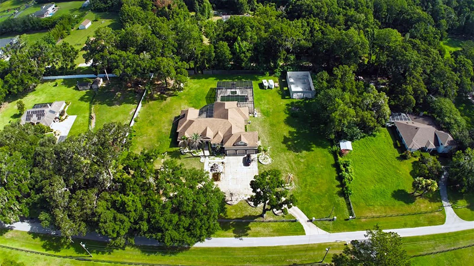 From the moment you arrive, it's clear this is no ordinary home. Set on a beautifully appointed 2-acre lot in one of Ocala's most desirable corridors, this magnificent 5,766 square foot estate is a masterclass in refined living, thoughtful design, and high-end craftsmanship that simply must be seen to be fully appreciated. Step through the front entry and into a massive, soaring foyer that immediately sets the tone for everything that follows. This is a home that commands attention and delivers on every promise. Hand-scraped hardwood flooring flows seamlessly throughout the residence, adding warmth and timeless elegance at every turn, while custom designer chandeliers and precision lighting create an ambiance that is both sophisticated and inviting in every room. The formal dining room is nothing short of stunning generously sized, bathed in natural light, and perfectly suited for hosting the most memorable gatherings. The gourmet kitchen is a chef's dream, featuring a professional-grade double oven, a iconic Sub-Zero refrigerator, and a gorgeous custom drop-in sink, all appointed with the finest finishes and fixtures money can buy. Every room in this home is expansive, thoughtfully designed, and finished with materials that reflect an uncompromising commitment to quality. Step outside and discover an entertainer's paradise unlike anything else in Ocala. The screened lanai and expansive outdoor living area are anchored by a stunning saltwater pool and jacuzzi, surrounded by lush landscaping and multiple large outdoor screen TVs for the ultimate al fresco experience. The centerpiece of it all is a dramatic oversized big screen TV mounted above a gorgeous gas fireplace positioned directly in front of the jacuzzi the perfect setting for unforgettable evenings under the Florida sky. Tucked above the spacious three-car garage, a impressive bonus room man cave offers the ultimate private retreat ideal for a home theater, game room, or private lounge. And for those with an eye toward future potential, a generous unfinished bonus structure on the back of the property presents a world of possibilities, whether you envision a custom in-law suite, additional garage space, a private barn, or something entirely your own. Situated in one of Ocala's most sought-after locations, this estate places you moments from world-class equestrian venues, upscale dining, premier shopping, and the very best that North Central Florida has to offer. Properties of this caliber, in this location, rarely come to market. As a final touch, this extraordinary estate is also being offered with the option to purchase fully furnished. Every piece of furniture throughout the home has been barely used and meticulously maintained, reflecting the same level of quality and sophistication as the residence itself. For the right buyer, this presents a rare and effortless opportunity to move in and begin living the luxury lifestyle from day one no shopping, no waiting, no hassle. Finally, if you're thinking bigger, the owner is also open to bundling this estate with a 10-acre property in the heart of the new SW 80th Ave expansion project. This amazing lot sits directly between Calesa Township and Del Webb's Stone Creek communities. Contact agent for more details.