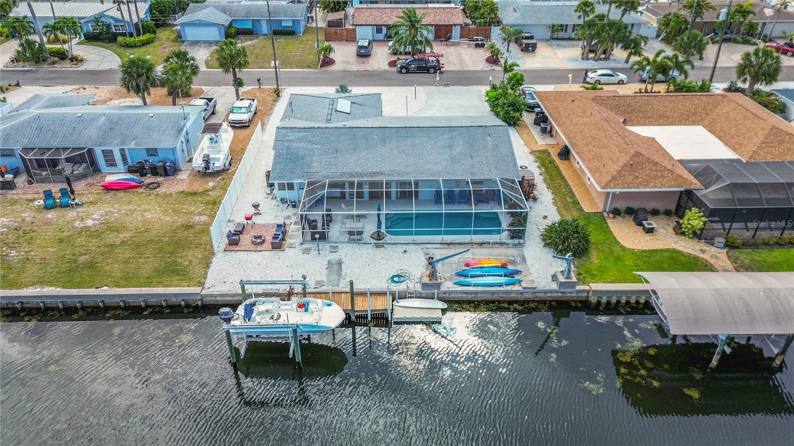 Welcome to the Florida waterfront lifestyle you’ve been waiting for. This 3-bedroom, 2-bath canal-front pool home offers direct, boatable access to the Gulf, putting world-class beaches, waterfront dining, and endless days on the water just minutes from your backyard.
Step outside and you’ll understand what makes this property special. A private dock with a boat lift makes it effortless to keep your boat ready for sunrise fishing trips, sunset cruises, or spontaneous weekends exploring the Gulf. No marinas, no hassle, just untie and go.
The outdoor living space is designed for how people actually want to live in Florida. Enjoy a sparkling pool perfect for cooling off on warm days, an outdoor kitchen ideal for hosting family and friends, and a firepit that creates the perfect setting for relaxing evenings by the water. Whether you’re entertaining a crowd or enjoying a quiet night under the stars, this home delivers. Inside, the 3-bedroom, 2-bath layout offers comfortable living with plenty of space for full-time residents, seasonal use, or guests. Every inch of this home is centered around maximizing the waterfront experience. This is more than just a home it is a lifestyle. Boating, entertaining, relaxing, and living minutes from the beach and Gulf access. The home has had recent updates to the kitchen counter tops, back splash, appliances, ceiling fans, electrical fixtures and lighting, cosmetic rebuild of garage, updated exterior pool bar with granite counter tops, shell landscaping with irrigation to planter beds.
