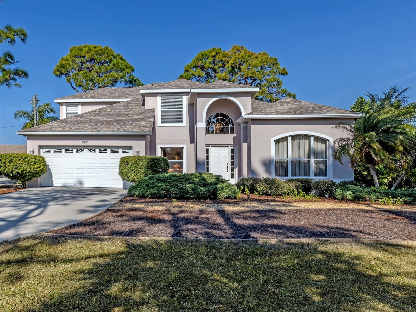 One or more photo(s) has been virtually staged. Wow factor custom built in 2000, three-bedroom, 2.5-bath, two-story home in short distance (1.8 miles) to Manasota Beach. UPDATE: NEW A/C MAY 2026...Seller giving a $3000 carpet credit at closing.  Home boasts 1,760-square-foot first floor and 1760-square-foot second floor of enjoyable living space. First floor features front entry foyer with 15-foot ceiling and glass chandelier, living room with decorative electric fireplace, family room with 17-foot ceiling, French doors leading to lanai. Formal dining room, kitchen with black appliances, under-counter reverse osmosis, raised panel cabinets, walk-in pantry and separate appliance closet, and recessed LED lights. Inside the laundry room with wash tub and storage shelves over the washer and dryer. Primary bedroom and bath with walk-in closet, soaking tub, double sinks and walk-in shower. Built-in central vacuum system. Storage closet under stairs leading to second floor. Second floor has 8-foot ceilings, two bedrooms and bath, and additional open hobby/playroom area. Home has attached two-car garage with painted floor, large work bench and pull-down stairs to attic. A 2024 Rheem 30-gallon hot water tank. Exterior has screened lanai, 50-year, 130-mph asphalt shingles installed in 2022, steel reinforcing bars for second floor to ground, outside shower and exterior entry door to half bath, and is prewired for future pool.  Steel and Lexan shutters for the entire home. Landscaped with Florida vegetation and Malibu lighting. Home has never had any flooding or wind damage, according to the owner.  Community features park with tennis courts, nature trails, playground, basketball courts. South Venice has private ferry to take you to private Gulf beach and private boat launch for a yearly fee if desired or enjoy the Manasota Beach area. Close to shopping and restaurants.