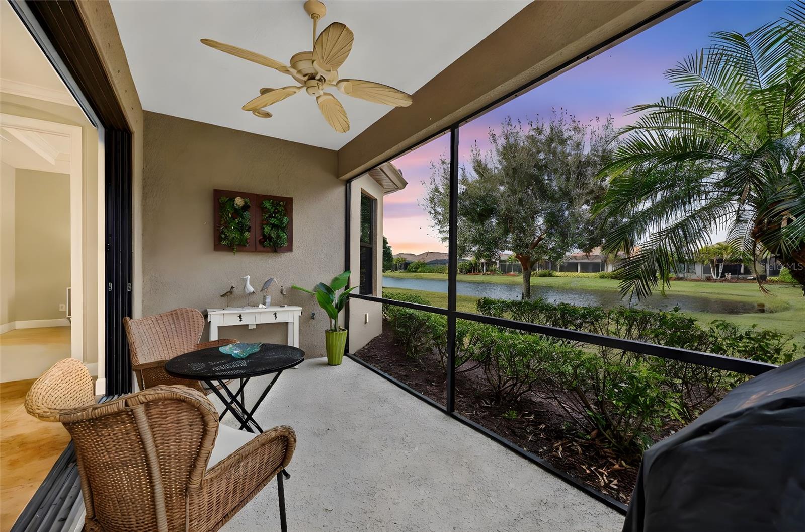 MAINTENANCE-FREE ELEGANCE WITH POND VIEWS! Welcome to your peaceful retreat in the prestigious gated community of Esplanade Golf and Country Club at Lakewood Ranch. This 2-bedroom, 2-bath home with a den is a shining example of timeless style and modern convenience, perfectly situated on a premium oversized corner lot offering tranquil lake views. As you step inside, you’re welcomed by soaring 8-foot doors, elegant tray ceilings, crown molding, and arched doorways that add architectural charm throughout. The main living areas feature tile flooring for effortless maintenance, while the bedrooms are carpeted for added comfort. The chef’s kitchen is both functional and stylish, showcasing stainless steel appliances, pull-out drawers, a spacious layout, and beautiful pendant lighting above the bar—ideal for entertaining. Impact-filmed window treatments and ceiling fans throughout provide year-round efficiency and comfort. Recent updates enhance the home's value and include attic insulation replaced in 2024 by Hughes Pest Control, a new garbage disposal installed in 2025, and a freshly painted exterior in 2025. The home is also plumbed for a future summer kitchen, and the lanai has expansion potential. Functional upgrades like gutters and recessed lighting complete the package. The spacious primary suite offers dual sinks, a walk-in closet, and a luxurious ensuite bath. The second bedroom also includes a walk-in closet, making it perfect for guests or extended stays. Residents of Esplanade enjoy access to world-class amenities including pools, fitness center, tennis, pickleball, clubhouse, and more—all within one of Lakewood Ranch’s most desirable lifestyle communities and is located in the heart of Lakewood Ranch, close to I-75, Lakewood Ranch Main St., University Town Center, Sarasota Polo Club, shopping, dining, entertainment, hospitals, cultural attractions, boating, parks and Florida's famous sandy beaches. This is a Club Home where you can pay to play golf.  Glass décor in dining room and grill DO NOT CONVEY.