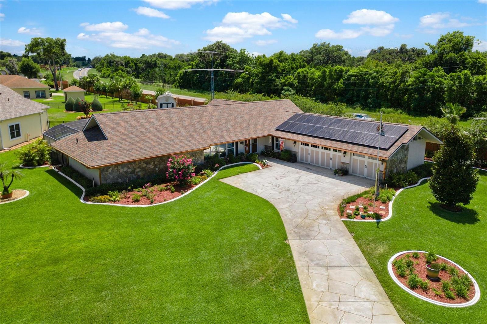 ENERGY EFFICIENT DREAM HOME...CHAIN OF LAKES ACCESS! Imagine enjoying little to no electric bills while living in a beautifully customized owner-builder home loaded with upgrades. German-made solar panels, solar hot water heater, and three Tesla batteries provide enough energy to offset up to 100% of the electric bill, while a Generac generator offers added peace of mind. Remodeled and upgraded throughout, this spacious home features a cathedral-ceiling great room, a luxurious primary suite with multiple closets, spa-inspired bath, granite kitchen, and flexible living spaces perfect for family, guests, or a home office. The heated and air-conditioned garage adds even more versatility. Step outside to your private saltwater pool with fountain, outdoor shower, manicured landscaping, and charming mini barn for storage. Best of all, enjoy Chain of Lakes access to Little Lake Harris with shared dock ownership—perfect for fishing, boating, and making memories on the water. Numerous extras convey, including TVs, electronics, patio furniture, lawn tractor, pool cover, and more. New roof in 2021, fiber internet, home theater wiring, water softener, UV air purification, and countless additional upgrades make this home truly move-in ready.