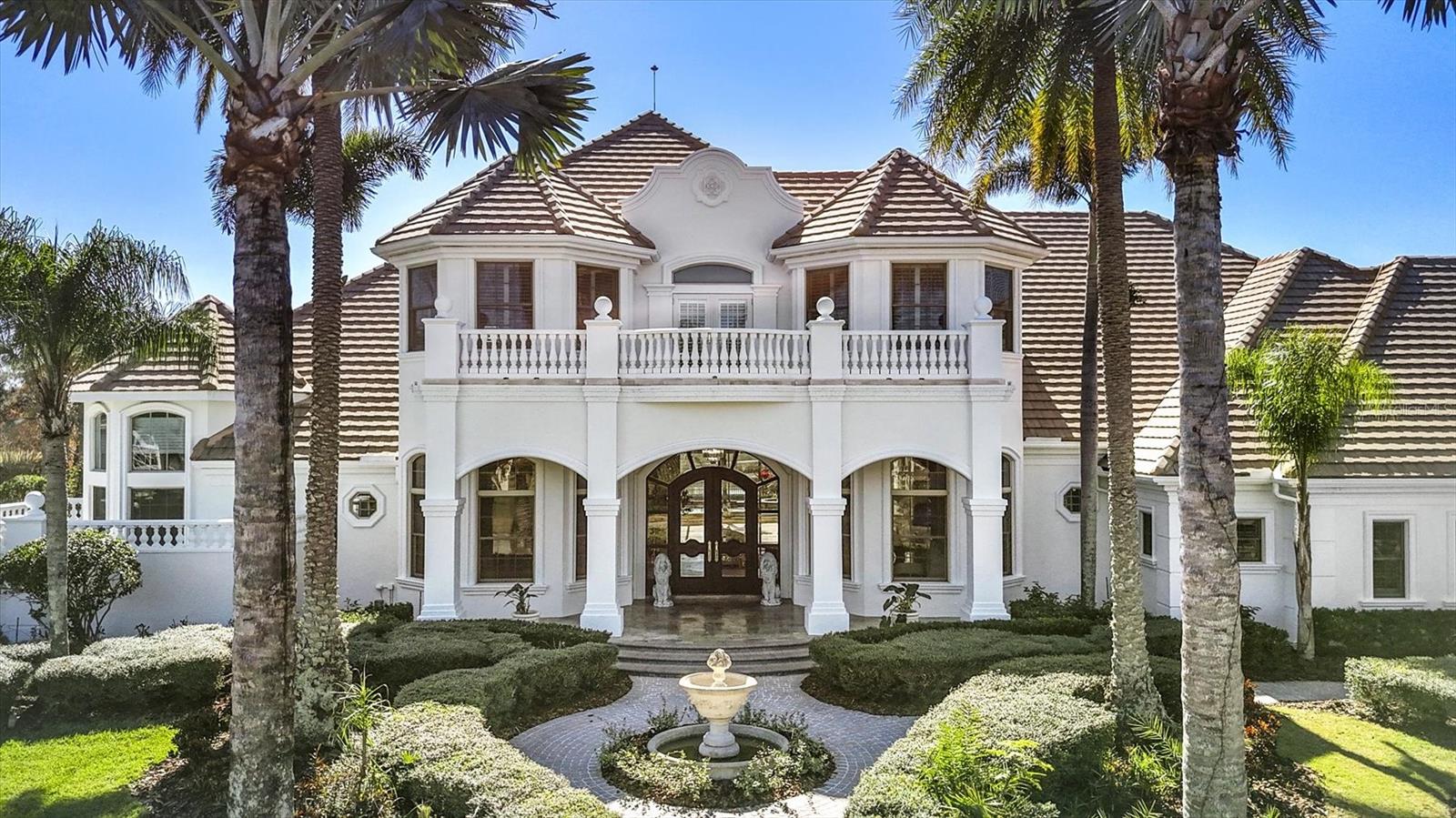 One or more photo(s) has been virtually staged. Discover an exceptional opportunity to own one of the most distinguished estates in the gated, exquisite community of Lakewood Ranch Country Club. Perfectly positioned on an expansive .94-acre double lot, this rare residence offers unmatched privacy, generous outdoor living with fenced in backyard, and a sense of scale that is impossible to replicate within the community. Elegance unfolds from the moment you arrive. A stately residence, framed by mature landscaping and sweeping lawn, creates a grand entrance worthy of the home’s impressive setting. Inside, refined architectural details, soaring ceilings, and sun-filled living spaces blend seamlessly to create an atmosphere of timeless sophistication and effortless livability. Designed for both intimate relaxation and stylish entertaining, the home’s open layout flows beautifully from formal living and dining areas to the spacious family room and gourmet kitchen. Large picture windows and multiple sets of glass doors draw in natural light while offering tranquil views of the estate-sized grounds, ensuring every room feels connected to the outdoors. The primary suite is a serene escape, generously proportioned and thoughtfully designed with a spa-inspired bathroom, separate sitting area for exercise or relaxation, expansive closet with custom built-ins, and private access to the lanai. Four additional ensuite guest rooms provide comfort and privacy for visitors, while a dedicated office or den offers the perfect space for work or quiet retreat. Outdoors, the true uniqueness of this property comes to life. The nearly one-acre homesite offers an extraordinary sense of openness rarely found in Lakewood Ranch Country Club. The expansive lanai and screened pool area overlook lush, beautifully manicured grounds—ideal for hosting gatherings, creating a private garden oasis, or simply enjoying the tranquility of your own oversized retreat. In one of the most desirable gated golf communities, residents of Lakewood Ranch Country Club have the opportunity to enjoy 72 holes of challenging golf, tennis, pickleball, swimming, a state-of-the-art fitness center, and three elegant clubhouse options with dining and social events. The location offers unbeatable convenience, just minutes from University Town Center, world-class shopping and dining, I-75, and the Gulf Coast’s celebrated beaches.With its rare double lot, impressive footprint, and timeless architectural appeal, 7028 Portmarnock Place presents a singular opportunity to own a private estate that stands apart from the rest. This is more than a home—it is a legacy property, offering space, elegance, and the freedom to live exceptionally in the heart of Lakewood Ranch, the most desirable master planned community in the country.