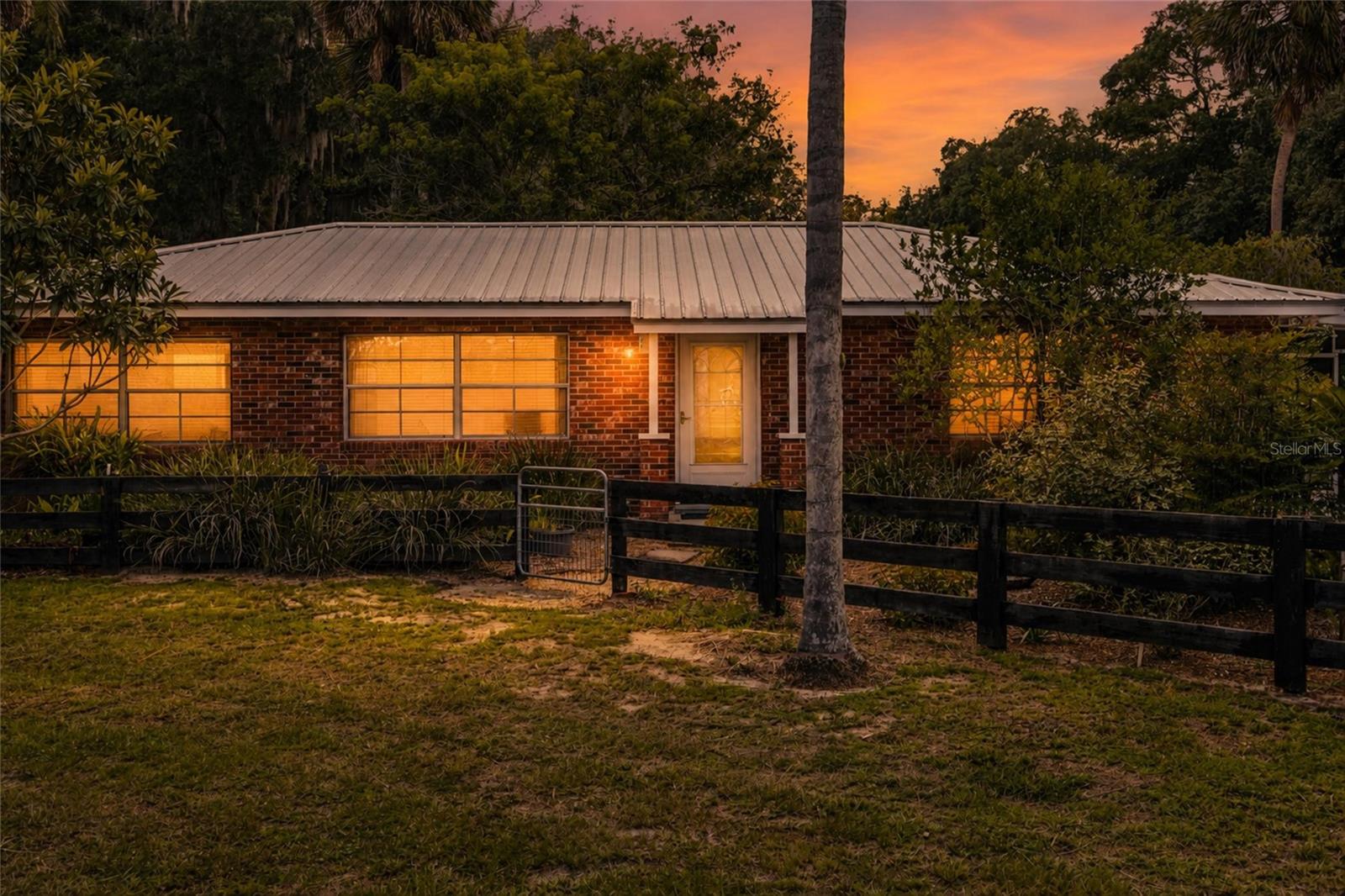 Charming brick pool home on 5 fully fenced acres with a detached 1-bedroom, 1-bath apartment, massive 4,000± sq. ft. workshop/barn, and approximately 460 feet of frontage on County Road 439! The main home features 2 bedrooms, 2 baths (3 bedrooms and 3 baths total including the detached apartment), a durable metal roof, and an expansive screened porch overlooking the pool that is perfect for relaxing or entertaining.
The impressive block workshop/barn offers concrete floors, a metal roof, and endless possibilities for equipment storage, hobbies, business use, or recreational vehicles. Barn could easily be converted back to a functional horse barn, making it ideal for equestrian enthusiasts also!
 
Attached to the barn is a fully equipped 1/1 apartment with a full kitchen, ideal for guests, extended family, a caretaker, or potential rental income. The workshop and apartment are separately metered from the main home for added flexibility.
Bring the RV, animals, toys, and all your plans! There is even an RV hookup already in place. 
Whether you're looking for a private homestead, hobby farm, income-producing opportunity, or a live, work, and play property, this versatile acreage is packed with potential!