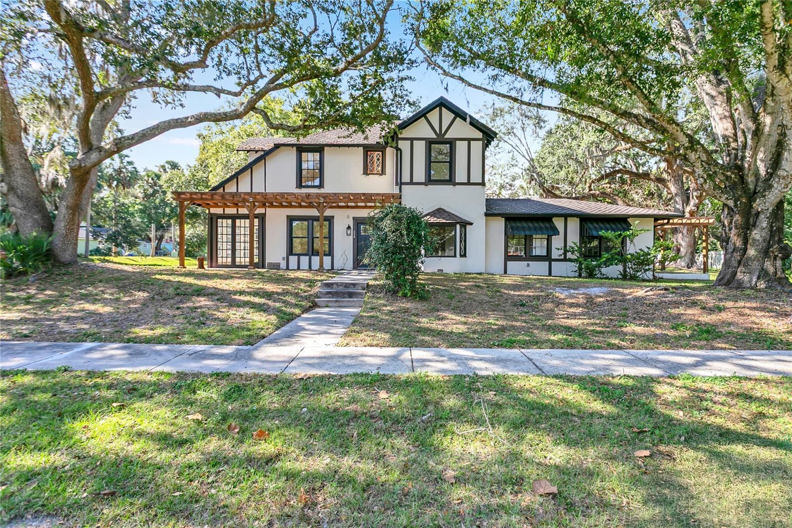 Welcome to this Remarkable 2-Story Tudor Home in the Mayfair District of Sanford. This Home has been Recently Refreshed Capturing the Allure of Historic Features with Modern Conveniences. Situated on a Corner Lot This 4 Bedroom/2.5 Bath Home is Definitely Not to Be Missed. Enter Through the Front Door to a Formal Entry which Opens to the Dining Room on the Right. The Bay Window of the Dining Room Looks Out to the Front Yard Allowing the Morning Sunlight to Stream In. Come Enjoy Meal Prep and Entertaining in the Updated Chef's Kitchen with 6 Burner Gas Stove, Custom Range Hood, Island with Microwave, and Plenty of Storage with an Abundance of Cabinets. The Private Primary Bedroom is Accessed off a Hallway off the Kitchen and Boasts an Ensuite Bathroom with Walk In Shower and a Walk In Closet with Built-Ins. The Living Room with a Decorative Fireplace is on the Left Side of Home and Connects to a Sunroom with 3 Walls of Windows Looking onto the Oak Shaded Side Yard. A 1/2 Bath and a Laundry are Tucked in Between the Kitchen and the Living Room. 3 Bedrooms and an Updated Full Hall Bathroom Upstairs. There is a Covered Back Patio and a 2 Car Garage with Driveway that Adds to the Appeal of this Home. Located a Short Distance to Downtown Historic Sanford with Restaurants, Galleries, Shops, Breweries, Riverwalk and Marina are all Easily Accessible from this Home. Golf Cart Zone Location Adds to the Ease of Access. Don't Miss Out on This Wonderful Home.