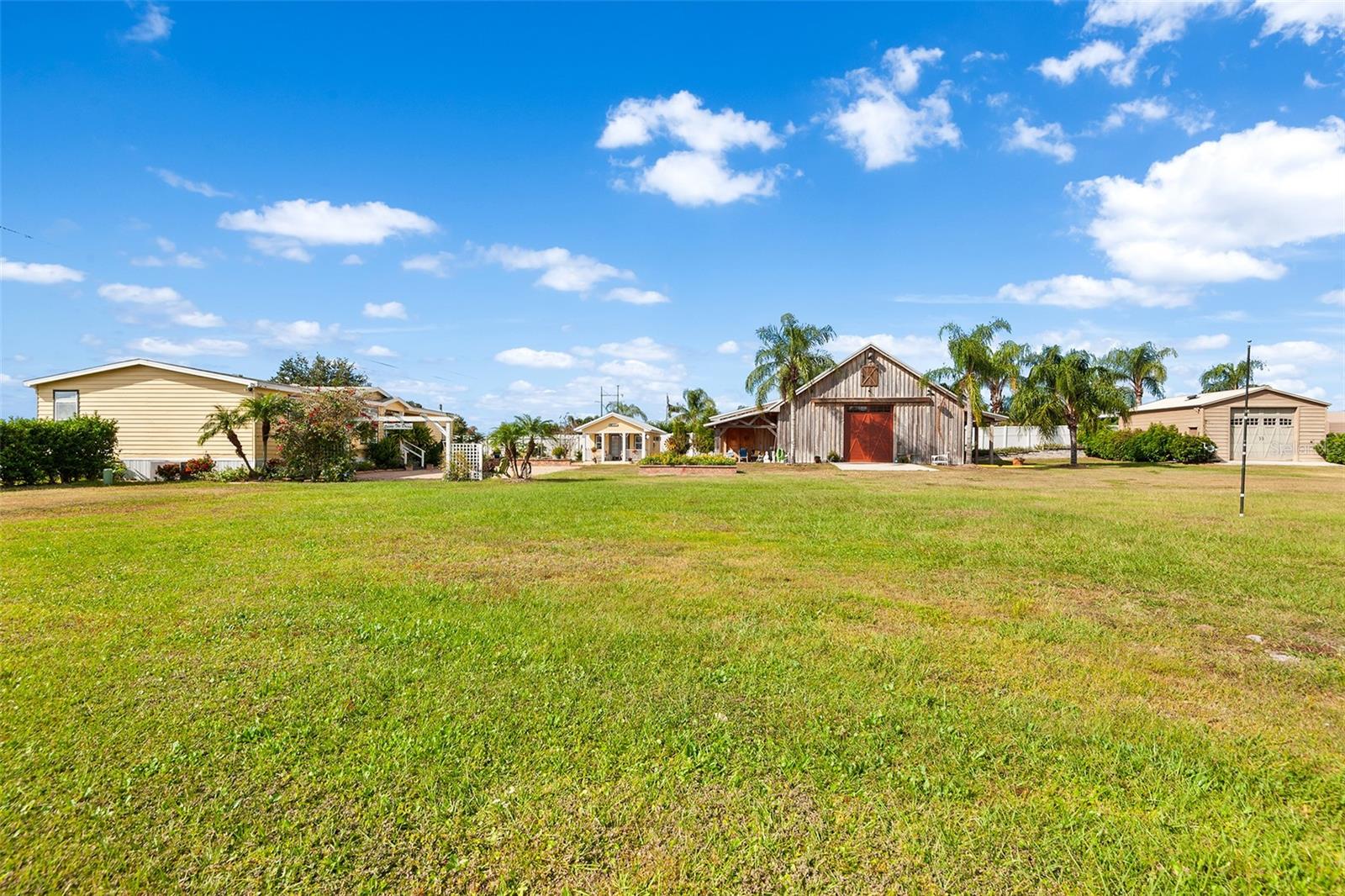 Discover a rare multi-use acreage property in Polk City, Florida offering over 3 acres of fenced land, lake views, and private access to Lake Mattie. Located in Polk County between Tampa and Orlando with convenient access to the I-4 corridor, this versatile property provides privacy, flexibility, and opportunity with no HOA and no lease restrictions.

The main residence is a beautifully remodeled 3 bedroom, 2 bath manufactured home offering approximately 2,070 square feet of living space. The home features abundant natural light, tray ceilings, crown molding, luxury vinyl plank flooring, and thoughtful updates throughout. The spacious kitchen includes Corian countertops, stainless steel appliances, and extensive cabinetry, ideal for everyday living or entertaining. Major updates include a roof approximately three years old and an AC system approximately five years old.

In addition to the main home, the property includes multiple outbuildings with living space, creating strong potential for multi-generational living, guest accommodations, rental opportunities, or home-based business use. The barn structure offers two additional bedrooms, one full bath, a kitchen, living area, office space, private entrance, and 200-amp service with a large 12-foot door, making it suitable for a workshop, studio, event space, or business operations. A detached she shed includes a half bath and outdoor shower, providing additional flexible space for guests or creative use. The property also features a large detached garage with RV parking, workshop area, and bath access.

Set on approximately 3.02 acres, the fully fenced and gated property includes multiple wells, fruit trees, expansive patio areas, and a whole-house generator for added peace of mind. With lake views and private access to Lake Mattie, this property appeals to buyers searching for acreage in Central Florida, a home with guest house or in-law suite, a property with barn apartment, an event venue opportunity, a home business location, or a private compound with land near Tampa and Orlando.

If you are looking for a lake access property with acreage and multiple living spaces in Polk County, this unique offering at 2799 Bay Lake Resort Road delivers flexibility, privacy, and long-term potential.