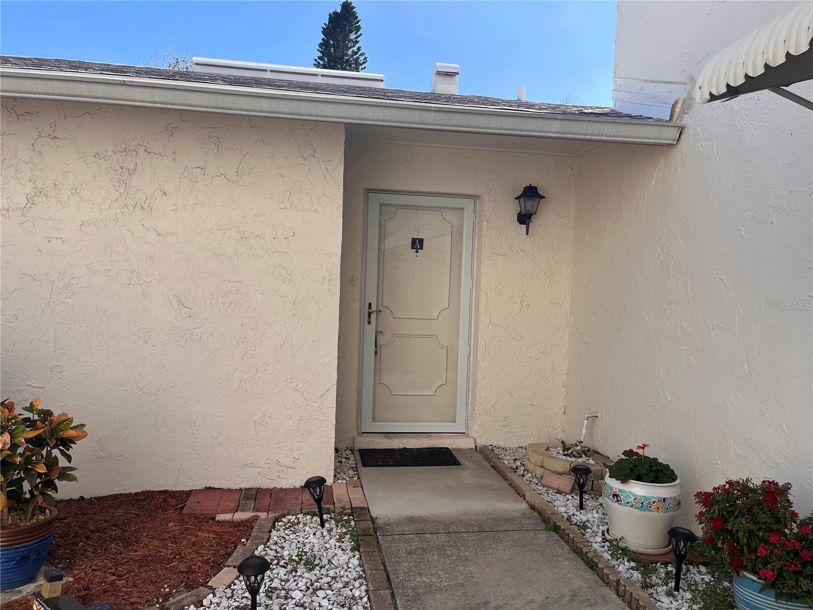 This 2 bedroom, 2 bath unit has been meticulously cared for!  There are porcelain tile floors throughout, impact-resistant windows and sliders, and custom window treatments.  The kitchen was updated with a cut-out for an open look, both bathrooms have been completely updated, one with a tub, one with a walk-in shower.  The a/c has been professionally serviced annually and functions perfectly.  Roof replaced in 2021 as well as the water heater and expansion tank.  The patio has been enclosed with white PVC basket-weave fence for esthetics and privacy.  There is a one car garage that has a storage closet.  This unit is ready for you to immediately move into and start enjoying as it has been professionally cleaned upon the Seller vacating.  West Shore Village a highly desired gated community. This community offers a number of amenities such as shuffleboard, a lovely picnic area, pickle ball/tennis courts, Pool and a clubhouse with a pool table and a lending library. The social complex hosts multiple parties and special events to enjoy all year round.  West Shore Village is a short commute from the bustling downtown and waterfront area of St Petersburg with its boutique shopping, dining, numerous museums, and many entertainment venues. Short drive to Fort DeSoto and the beautiful sands of St Petersburg Beach. Easy commute to Tampa and Tampa International Airport to the north and the iconic Skyway Bridge and Sarasota/Bradenton area to the south.  Come enjoy your slice of Paradise!!