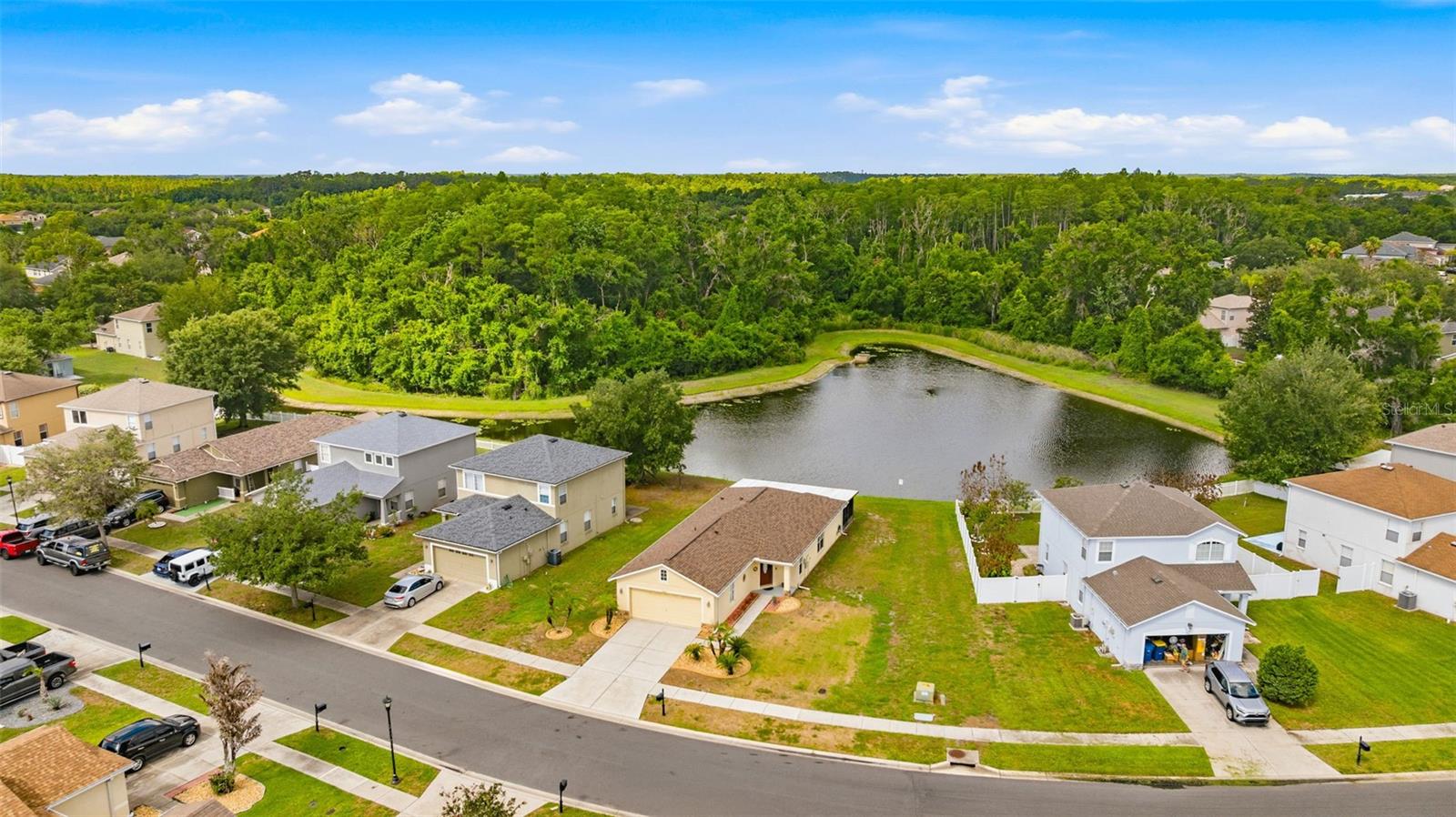 This exceptional waterfront residence in Asbel Creek offers picturesque pond views and refined living. The single-owner home provides 1,272 square feet of interior space, featuring three bedrooms, two bathrooms, a two-car garage, and a spacious screened and covered lanai measuring 360 square feet. Residents will appreciate both privacy and scenic surroundings, including direct pond frontage and a wooded backdrop with no rear neighbors. Notable improvements and amenities include a new roof May 2026, an updated AC unit (2021), a screened lanai spanning the entire width of the home's rear (12x30 feet), and a generously sized lot totaling 7,266 square feet. All windows and sliding doors feature double-pane glass for enhanced energy efficiency. Granite countertops are installed throughout, and the AC maintenance contract—paid through February 2033—is transferable. All appliances are included, and quick closing options are available.
Upon entry, the expansive great room serves as a combined living and dining area. The eat-in kitchen boasts granite surfaces, a closet pantry, pass-through bar to the dining area, bay window with sliding glass door access to the lanai, tile backsplash and ceramic tile flooring. The master suite is thoughtfully appointed with bay windows overlooking the backyard and pond, a walk-in closet, and a full bathroom with a walk-in shower. The split bedroom layout places the secondary bedrooms at the front of the home, sharing a full bathroom. Irrigation and gutters are an added feature. Great lot with plenty of room for entertaining, gardening or play. The community is well established and highly desirable, offering amenities such as basketball courts, volleyball, playground, and park, with no CDD fees and low HOA dues. Conveniently situated near schools, shopping, dining, healthcare, and recreational facilities, this growing area features new retail and commercial developments to meet increasing demand for residential living.