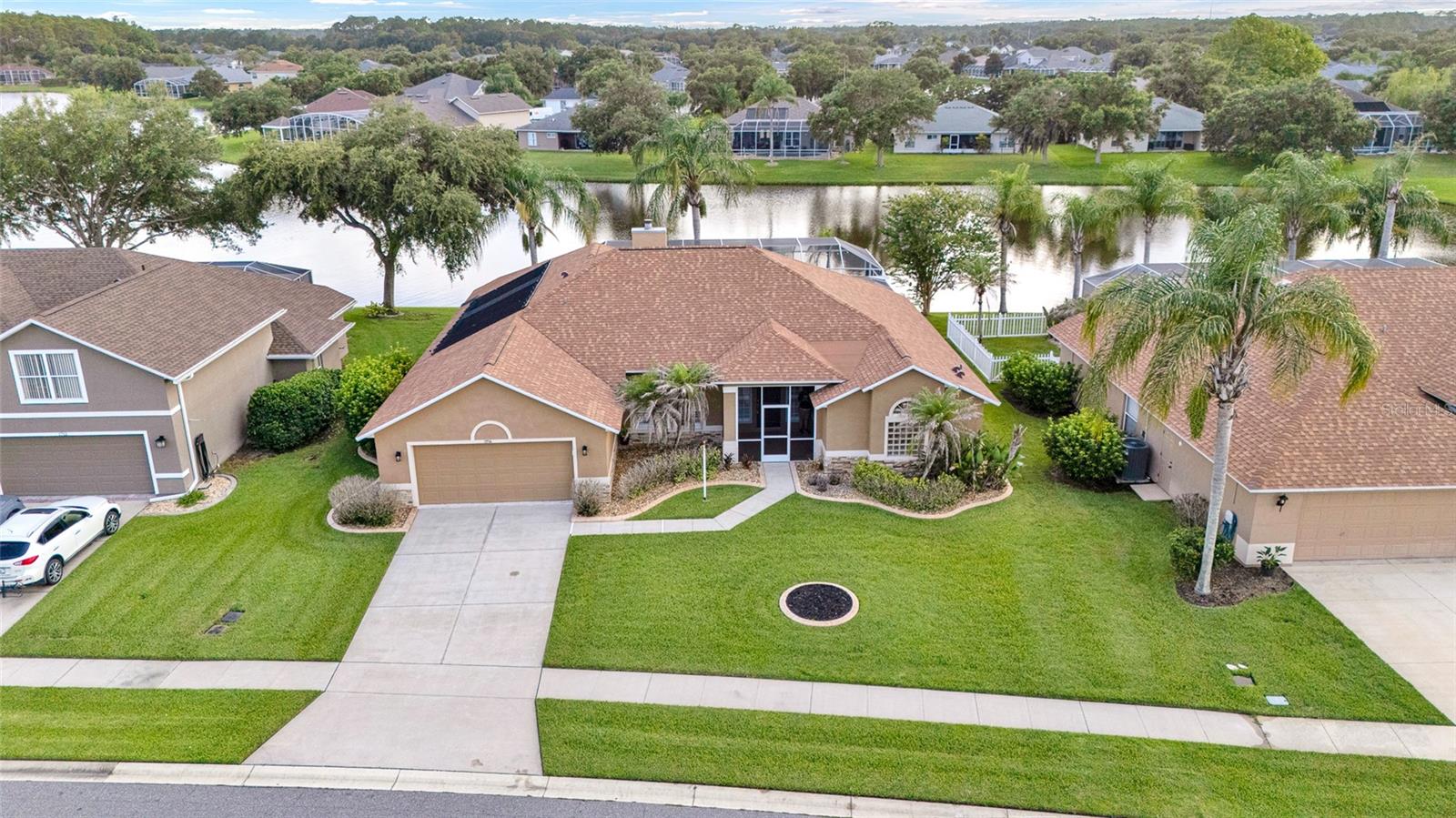 Welcome to one of the most sought after floor plans in Waters Edge, the Westminster. This well maintained 4 bedroom, 2 bathroom lakefront home offers a split bedroom layout, an oversized 2 car garage, and a screened saltwater pool, creating the ideal blend of comfort, privacy, and Florida living. Situated on a scenic waterfront lot, the backyard features a screened 2012 saltwater pool and an extended covered lanai, providing plenty of space for relaxing or entertaining while enjoying peaceful lake views. The screened front entry adds another inviting outdoor living space.
Inside, the home features tile flooring throughout the main living areas, tinted windows, hurricane shutters, granite countertops, raised panel cabinetry, and upgraded kitchen appliances. The spacious primary suite offers tray ceilings, abundant natural light, private access to the lanai, dual walk-in closets with upgraded shelving, dual vanities, a garden tub, and an updated walk-in shower. The guest bedrooms are privately located on the opposite side of the home, and the guest bathroom includes an updated shower. The exterior showcases stone accents, professionally maintained landscaping, decorative concrete curbing, palm trees, and river rock surrounding the home to help protect the exterior finish. Located in the desirable Waters Edge community, residents enjoy convenient access to nearby schools, parks, playgrounds, basketball courts, tennis courts, walking paths, and everyday shopping and dining. Additional highlights include a 2 car garage , a water treatment system, hurricane shutters, and negotiable furnishings.
