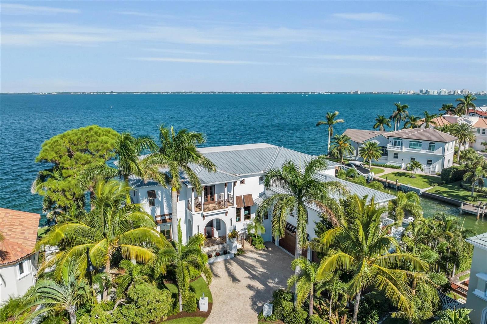 Discover the ultimate waterfront luxury at 620 Yardarm Lane, Longboat Key. This custom-built masterpiece by John Cannon Homes offers a sprawling 7,200 sqft of coastal elegance offering a FULL BAY VIEW that will take your breath away on the preferred south side of the street.
Situated in one of Longboat keys most prestigious neighborhoods with private deeded beach access, bike to St Armand's Circle & a short drive to downtown. 
As you enter this sophisticated coastal residence, a floating staircase welcomes you, setting the tone for the grandeur that awaits with 11-foot coffered ceilings. The attention to detail is evident throughout, with wide plank Hickory flooring that adds warmth and sophistication.
 
There is a beautifully appointed luxurious principal suite on the first floor, providing easy access and privacy.  
 
The open floor plan flows seamlessly connecting living spaces making it perfect for relaxation and entertainment with  
a wall of custom 10’ sliding pocket doors a fireplace with a custom stone mantle & 2 Capiz shell chandeliers.
 
In the sitting room, innovation takes center stage with a hydraulic lift for the television, ensuring uninterrupted bay views when not in use. Imagine gazing out at the water’s edge with the touch of a button. 
 
The gourmet kitchen includes an oversized Sub-Zero refrigerator, Wolf range & Carrara marble counter tops.   
A separate butlers pantry boasts convenience and style, featuring a Sub-Zero wine cooler & ice machine, Wolf warming drawer & an additional refrigerator & sink. Entertaining is a breeze with this well-appointed space. 
 
Beyond the kitchen is an elevator & a secondary staircase, leading you to a mezzanine floor, comprising a spacious office & game room with a wet bar. There is even a secret door leading to a large movie room—a hidden gem for film enthusiasts. 

 
Leading off from the living room is a terrace showcasing a true outdoor oasis, complete with sitting & dining areas and an outdoor fireplace, all thoughtfully protected from insects by an electrically operated drop-down screen. It’s the perfect place to unwind, or dine, while taking in the serene bay vistas. 
 
 
The outdoor area continues with an infinity edge pool & spa, where you can enjoy beautiful sunrises and spend the day soaking in the serenity of the bay. Picture yourself basking in the sun-drenched pool or enjoying evenings by the water feature-fire pit, all under the backdrop of the beautiful views of Sarasota Bay & Downtown. 
 
Other outdoor areas feature a built in Wolf gas grill & an outdoor shower plus multiple areas to sit or lounge while enjoying the warm Florida sunshine.  
 
 
On the second floor, discover four large ensuite bedrooms, each with balconies, plus a bonus children's room with built in bunks. Stay fit in the gym area and then step onto the large adjoining balcony with a full-size hanging bed and a spectacular panoramic bay view. 
 
 
The house features an extra-large three-car garage with ample storage areas and a full house generator. 
 
For the boating enthusiast this house offers both bay front & canal frontage. The large dock includes two boat lifts, a pair of jet ski lifts, kayak lift plus guest boat docking & a new seawall, this completes the picture of waterfront living. 
 
620 Yardarm Lane, Longboat Key, is not just a home, it’s a lifestyle: it's a haven of luxury and surprises. Come, experience the quintessence of Florida living at its finest.